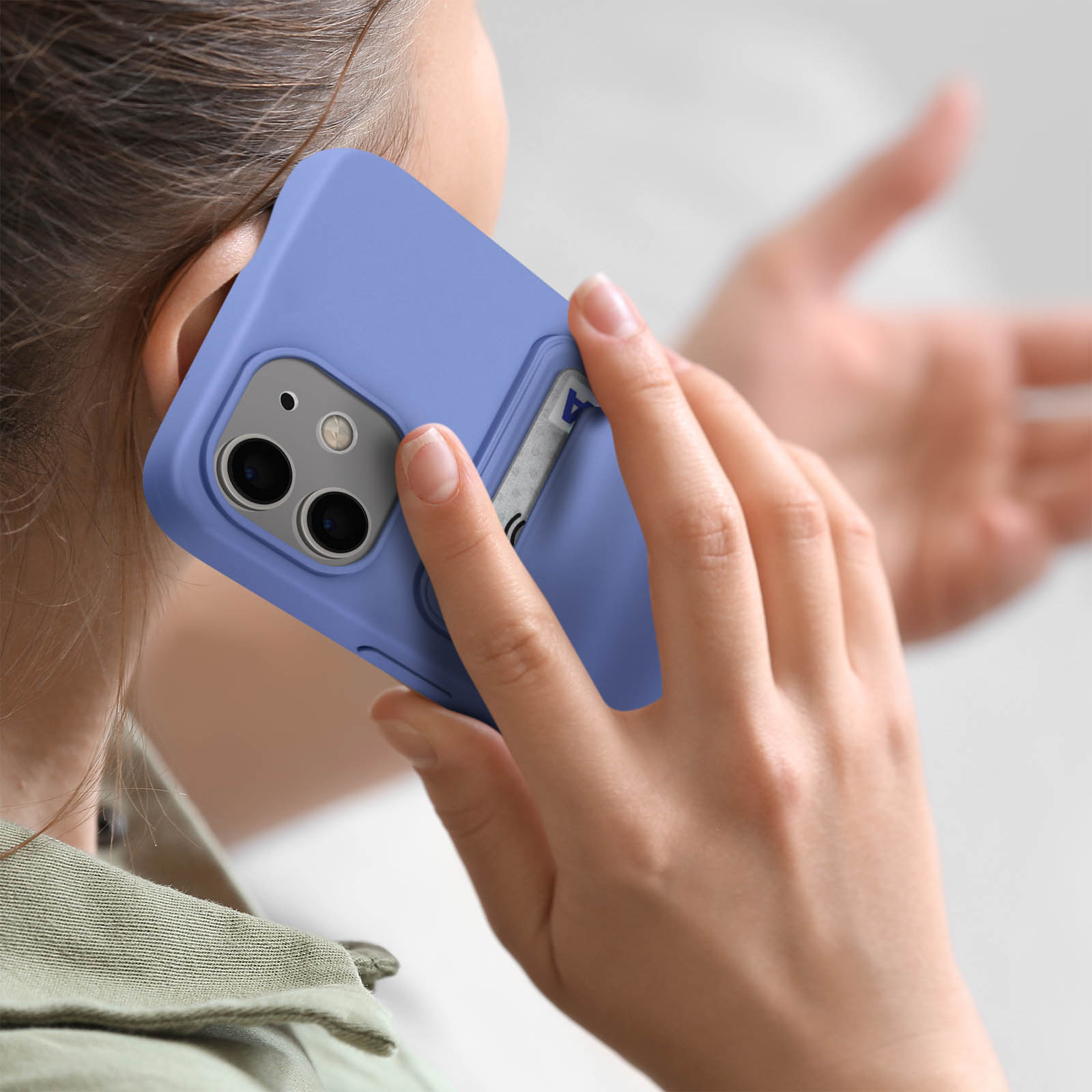 Una persona tiene una custodia blu per telefono all'orecchio.
