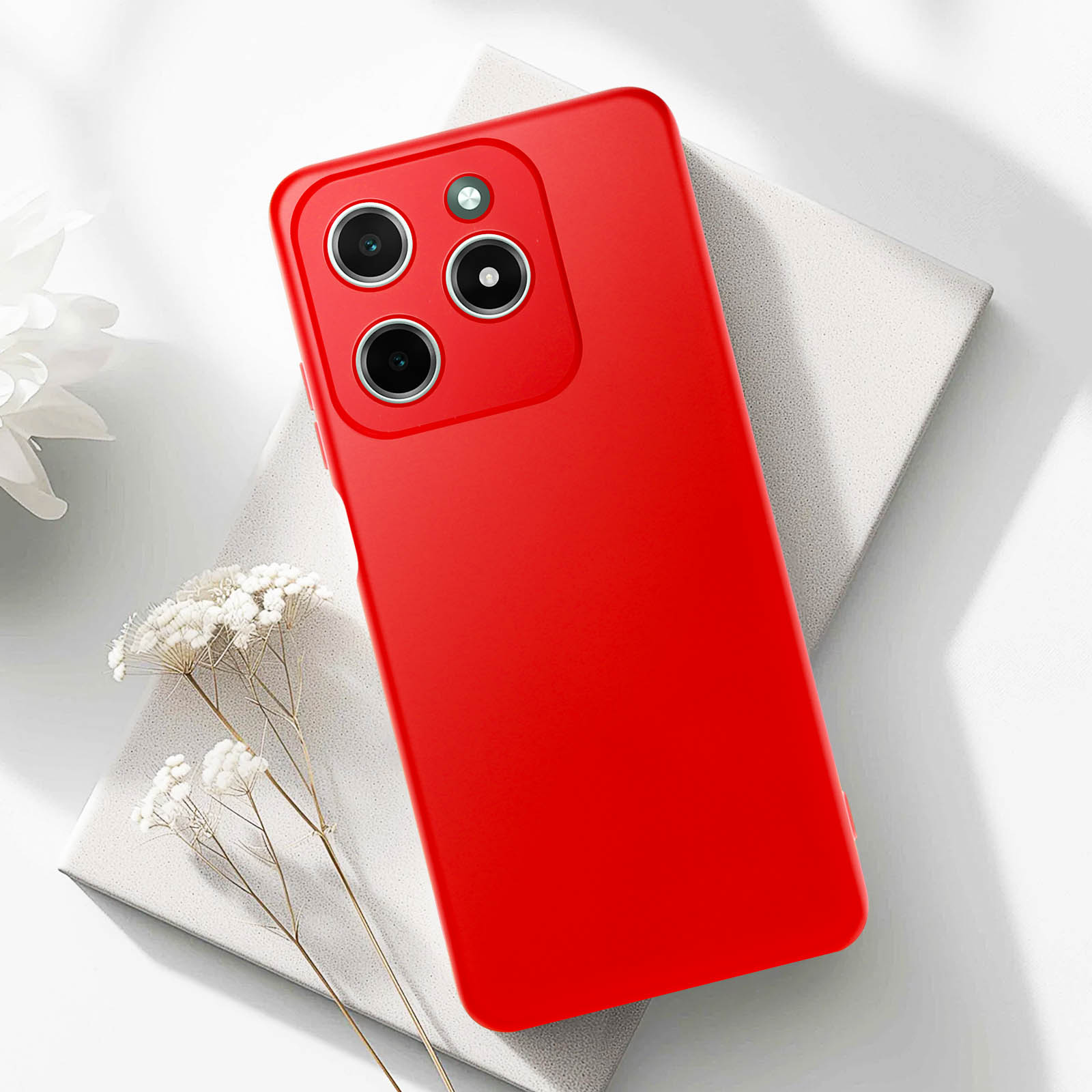 Telefono rosso su una superficie bianca. La custodia è rossa. Sfondo chiaro e neutro.