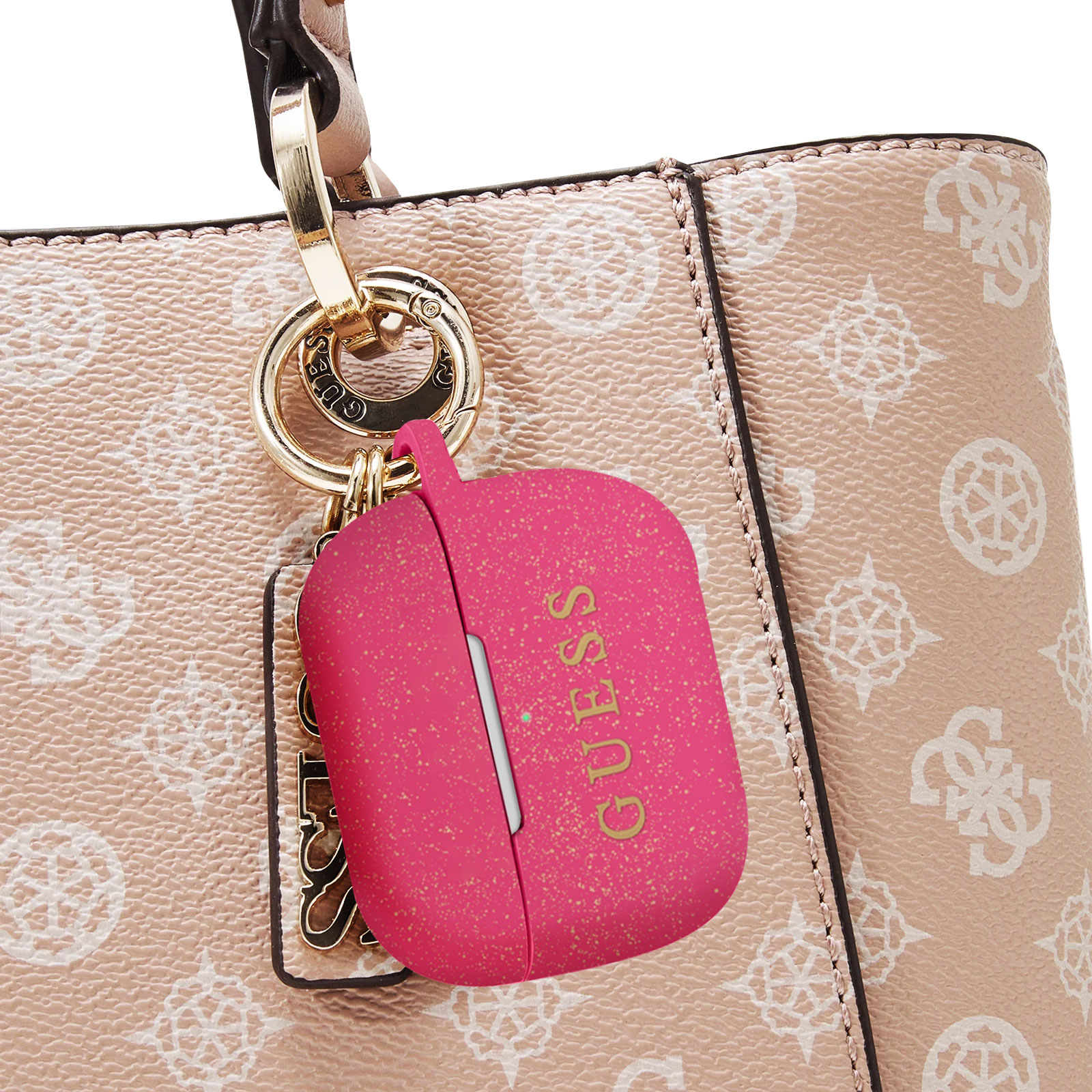 Funda rosa Guess para AirPod en una bolsa. La funda está abierta con el logo dorado de Guess y un cierre dorado.