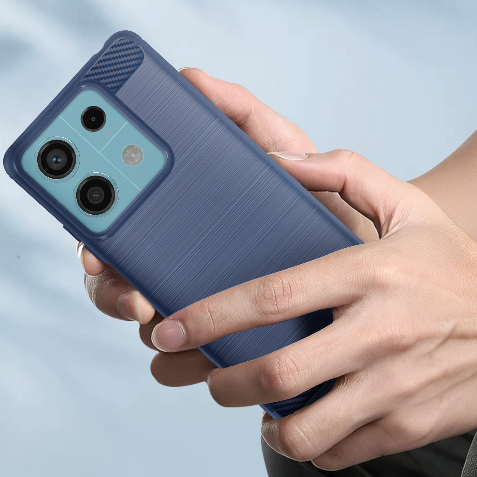 Mano che tiene una custodia blu per telefono. La custodia ha un design strutturato.