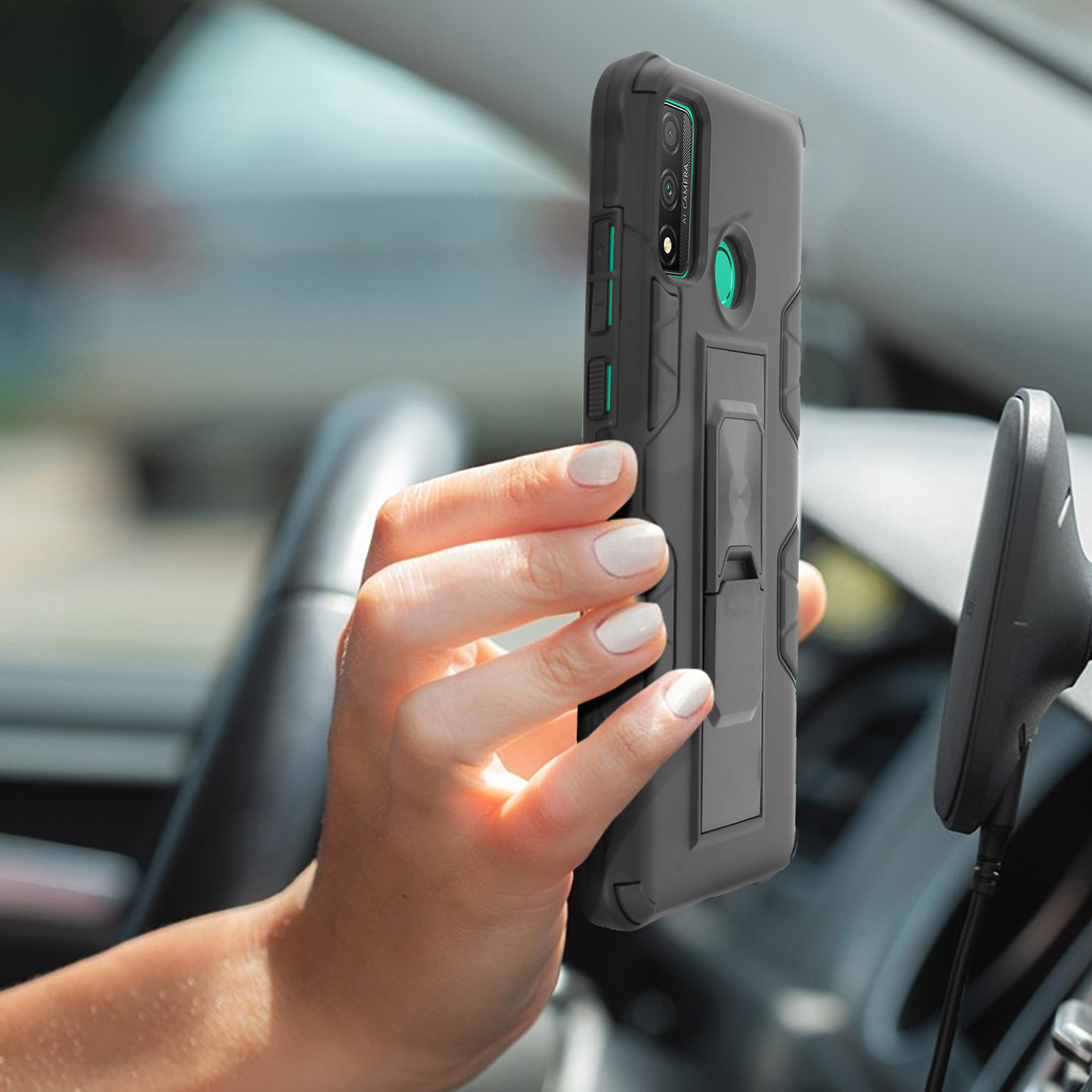 Persona che tiene un telefono in una custodia grigia. Il telefono è in auto.