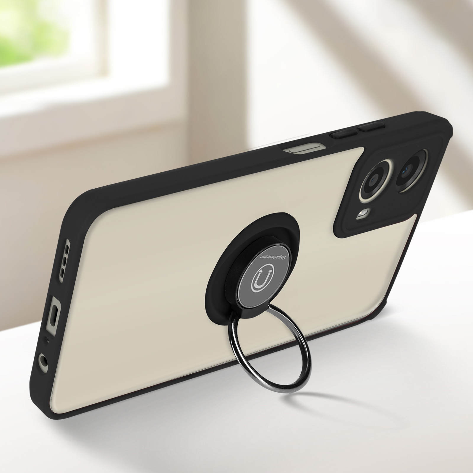 Un telefono con custodia nera e un supporto ad anello su una superficie bianca.