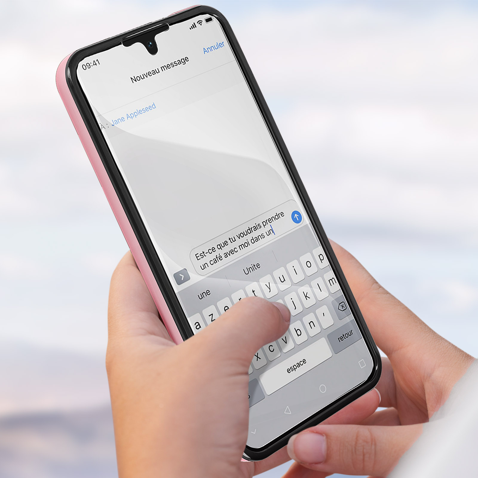 Una mano che tiene una custodia rosa per telefono con un telefono che mostra un messaggio di testo su una tastiera.