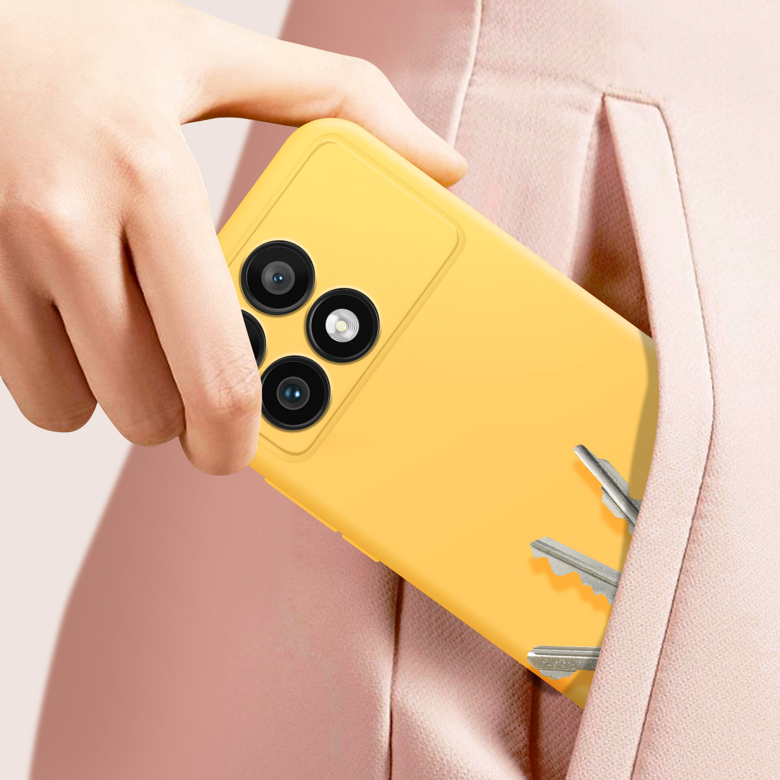 Mano che tiene un telefono giallo, chiavi in tasca, sfondo rosa.