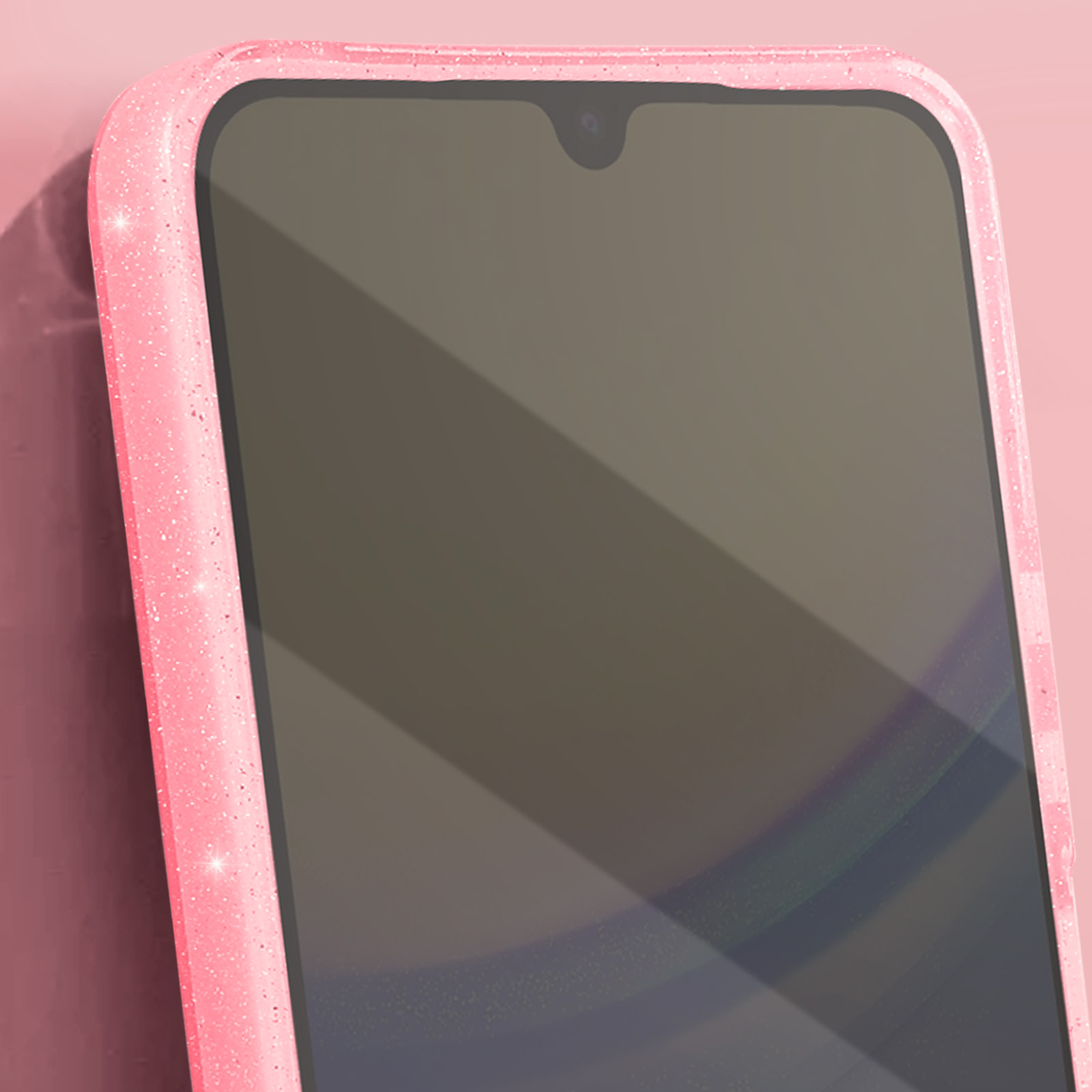 Telefono rosa con custodia rosa scintillante. Sfondo rosa e ombra laterale.