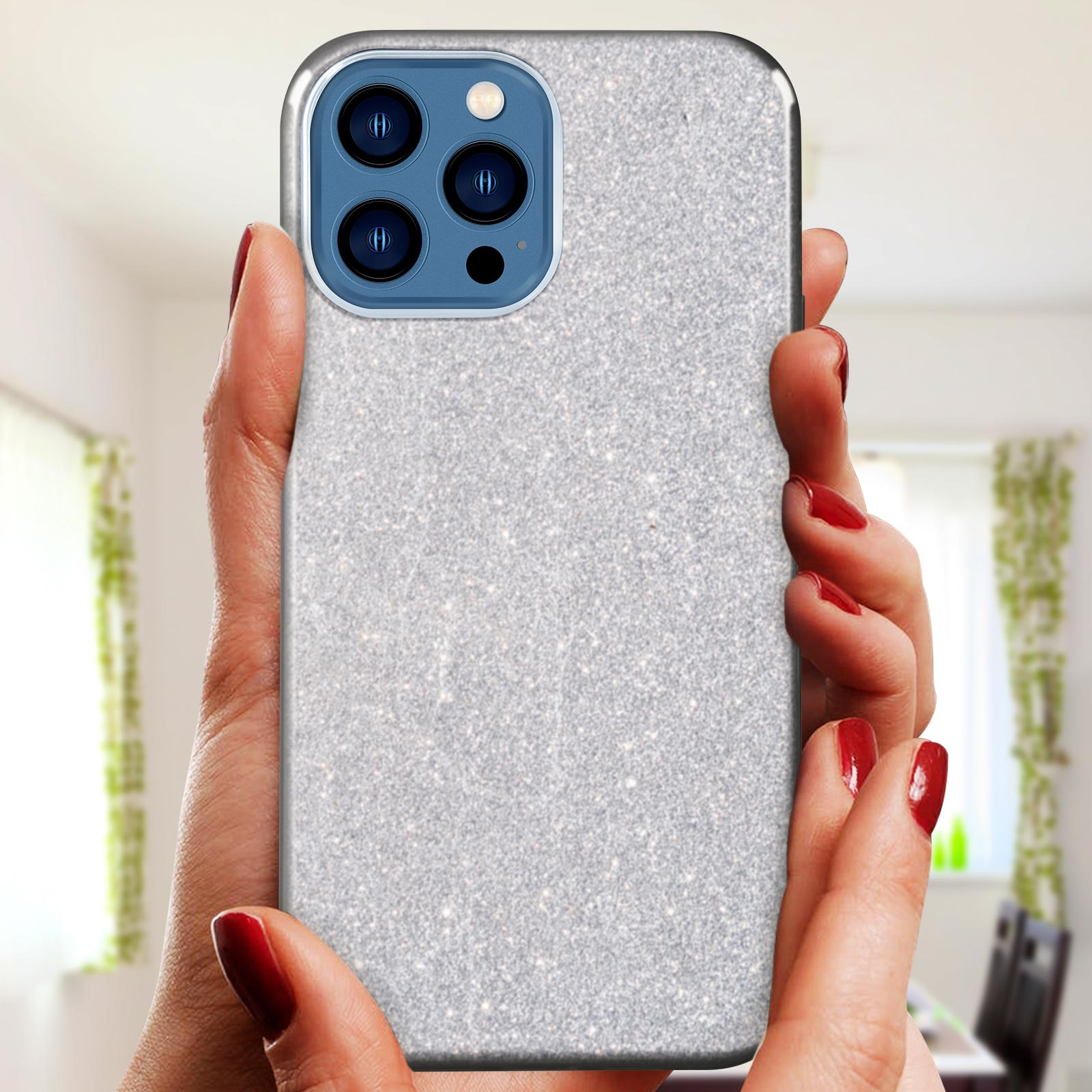 Mani che tengono una custodia per telefono con glitter. Il telefono ha tre fotocamere.