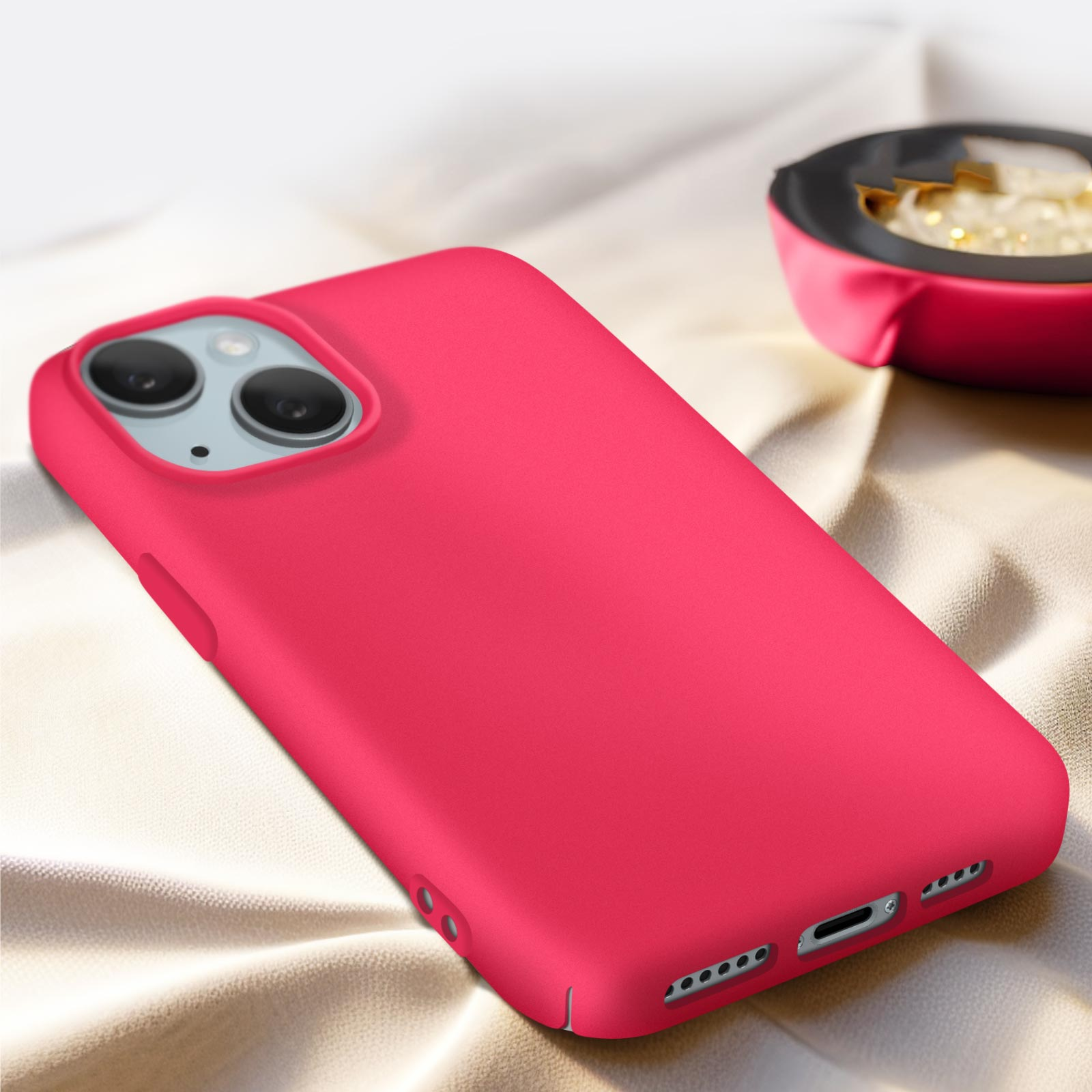 Custodia per telefono rosa con una superficie liscia su un tessuto, con un piccolo oggetto sullo sfondo.