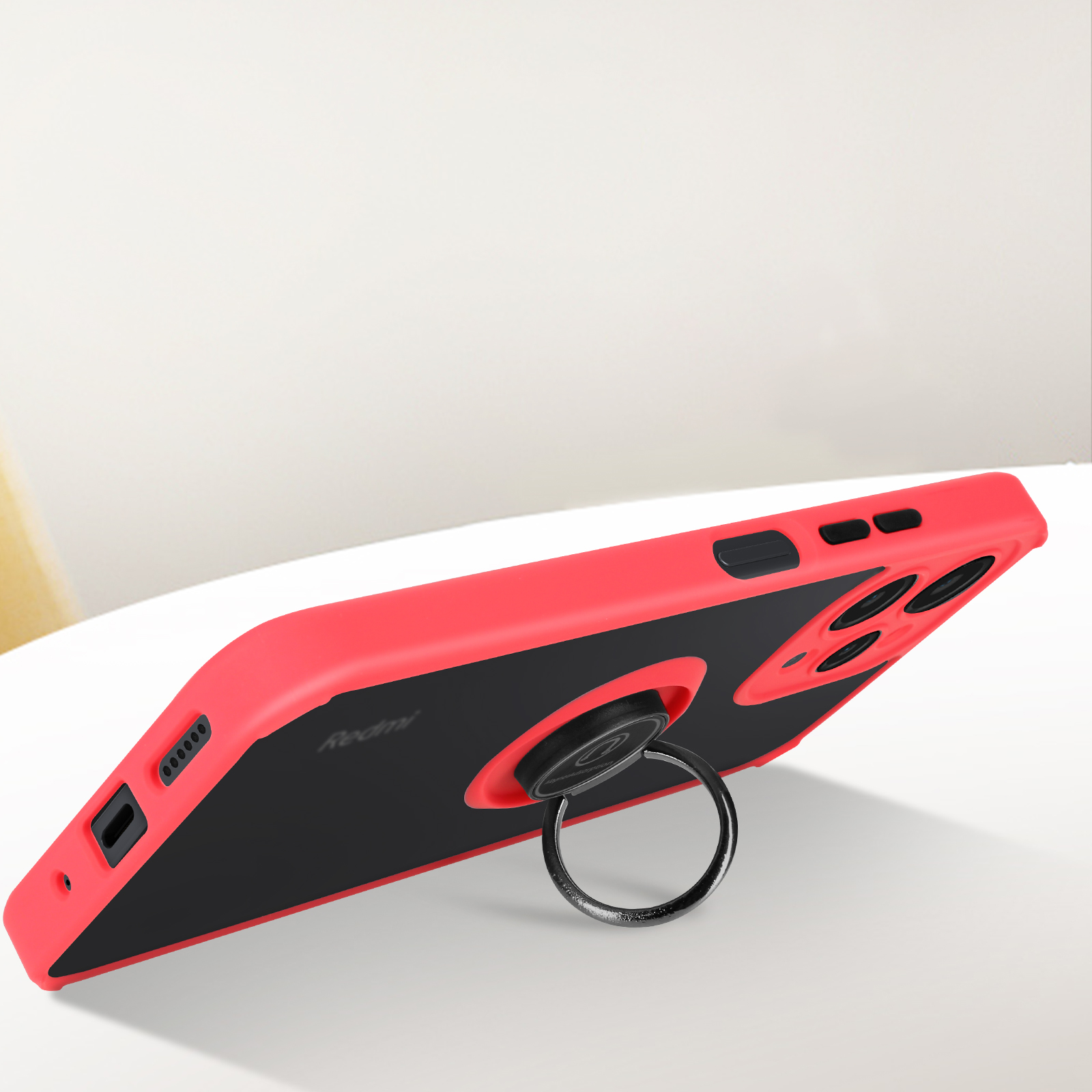 Custodia rossa e nera con anello di supporto su superficie bianca. Logo Redmi.