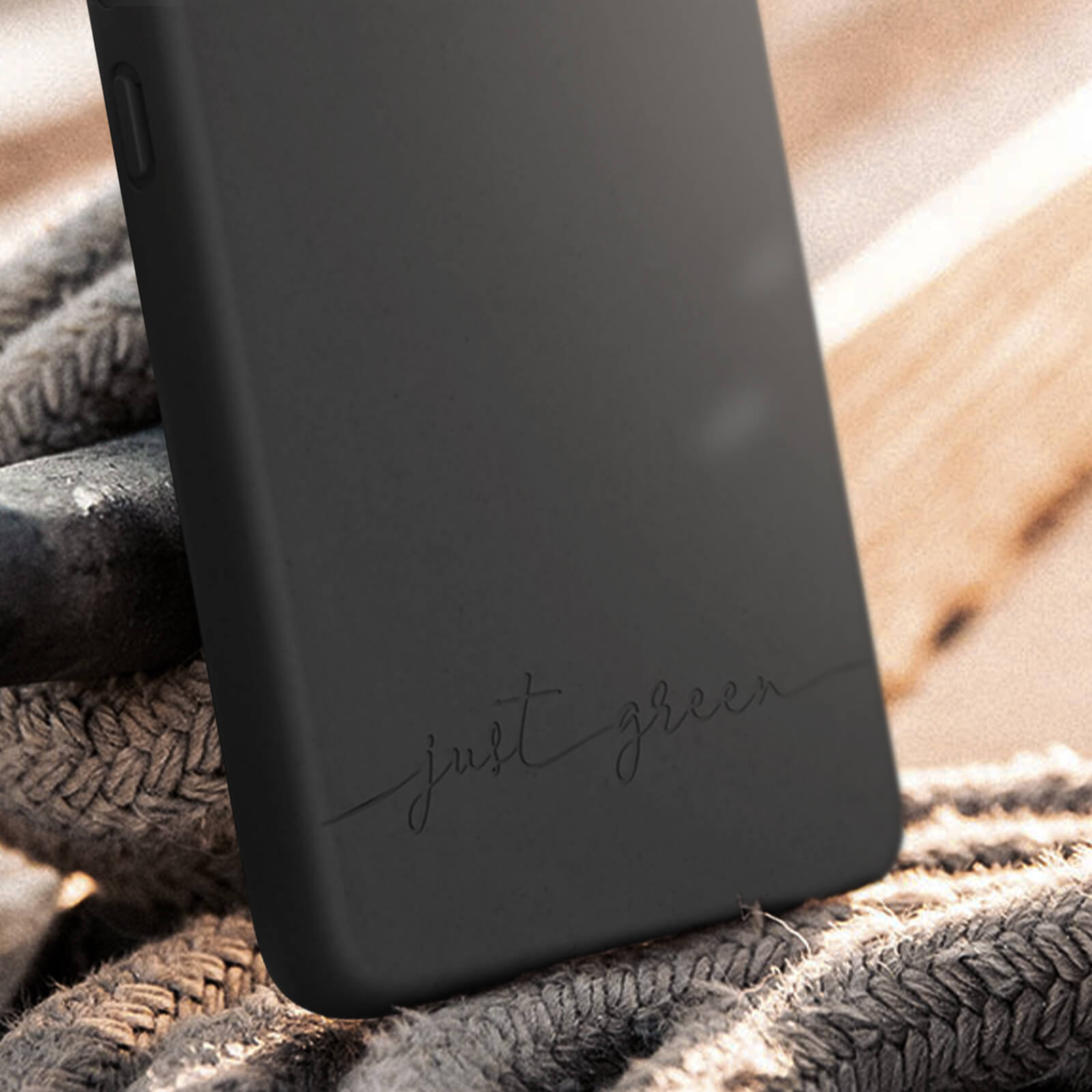 Custodia nera con scritto 'just green'. È posta su una corda.