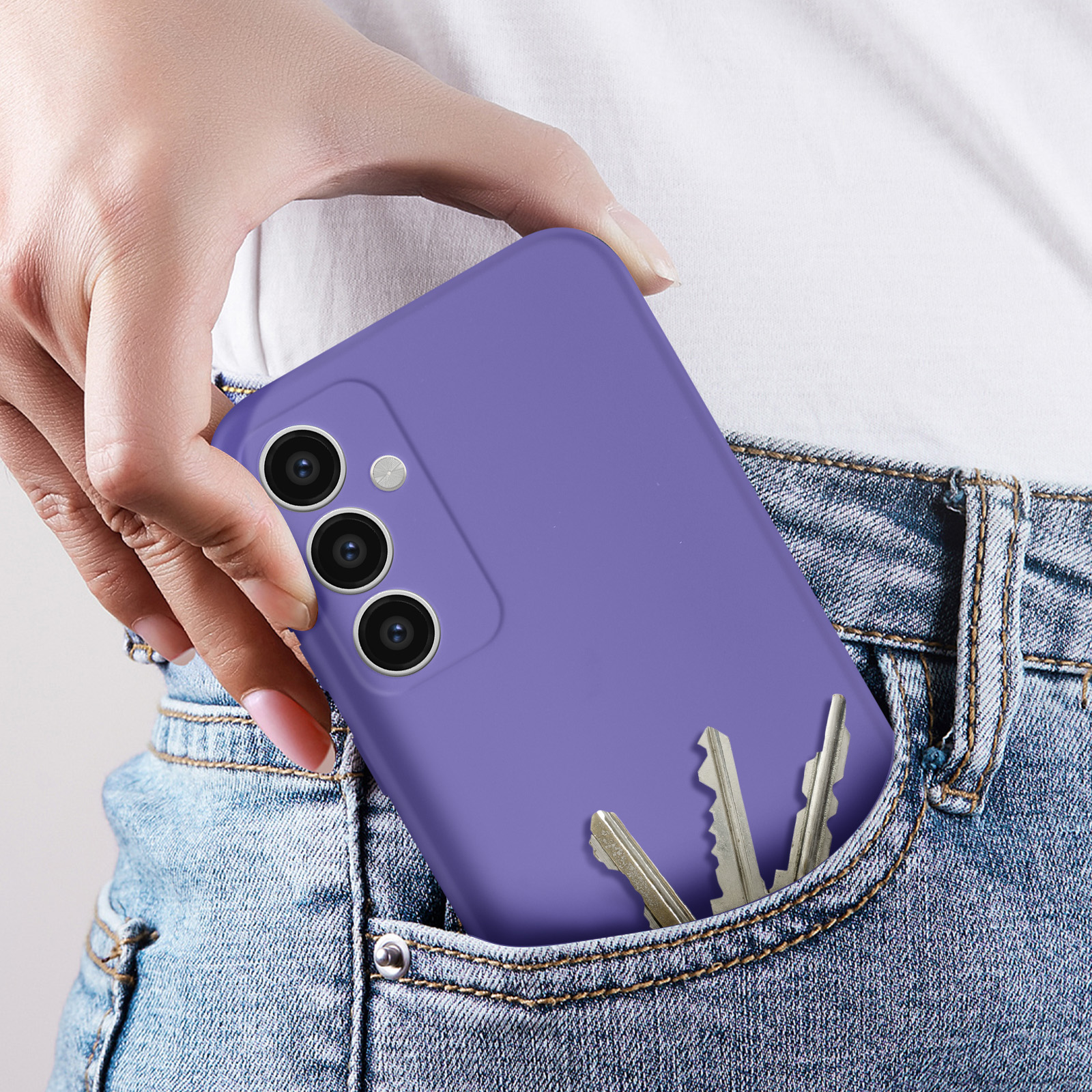 Un telefono viola in tasca. Il telefono è parzialmente visibile in una tasca di jeans, con chiavi.