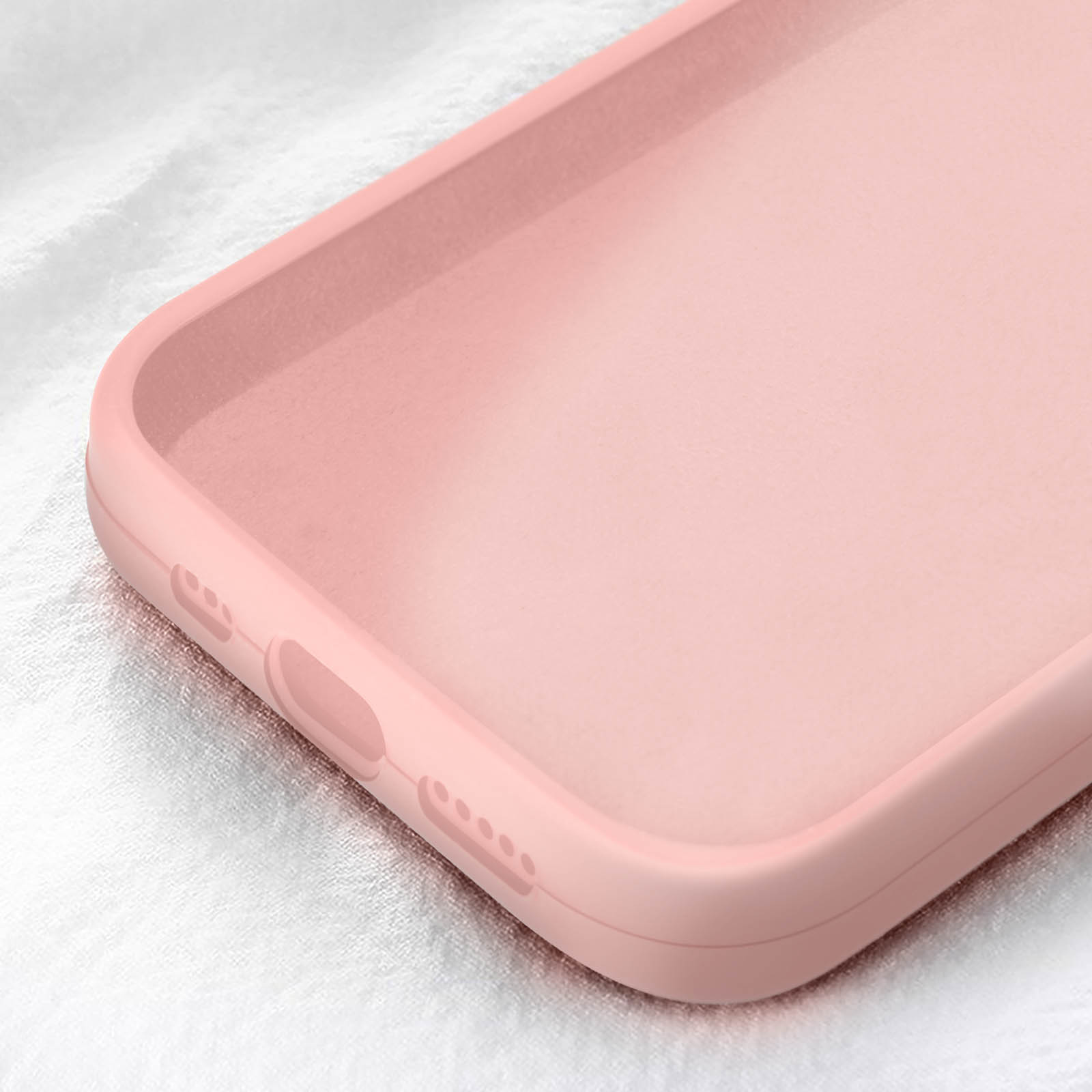 Primo piano di una custodia rosa per telefono, mostra porte e bordi arrotondati. Lo sfondo è una superficie bianca strutturata.