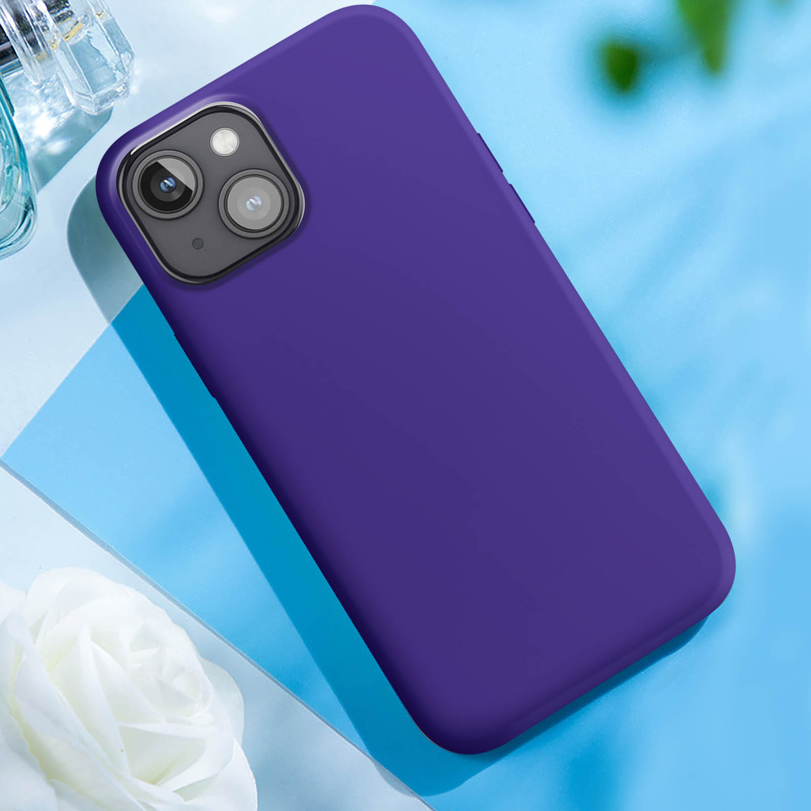 Custodia viola per telefono su una superficie blu. Ci sono alcuni oggetti sullo sfondo.