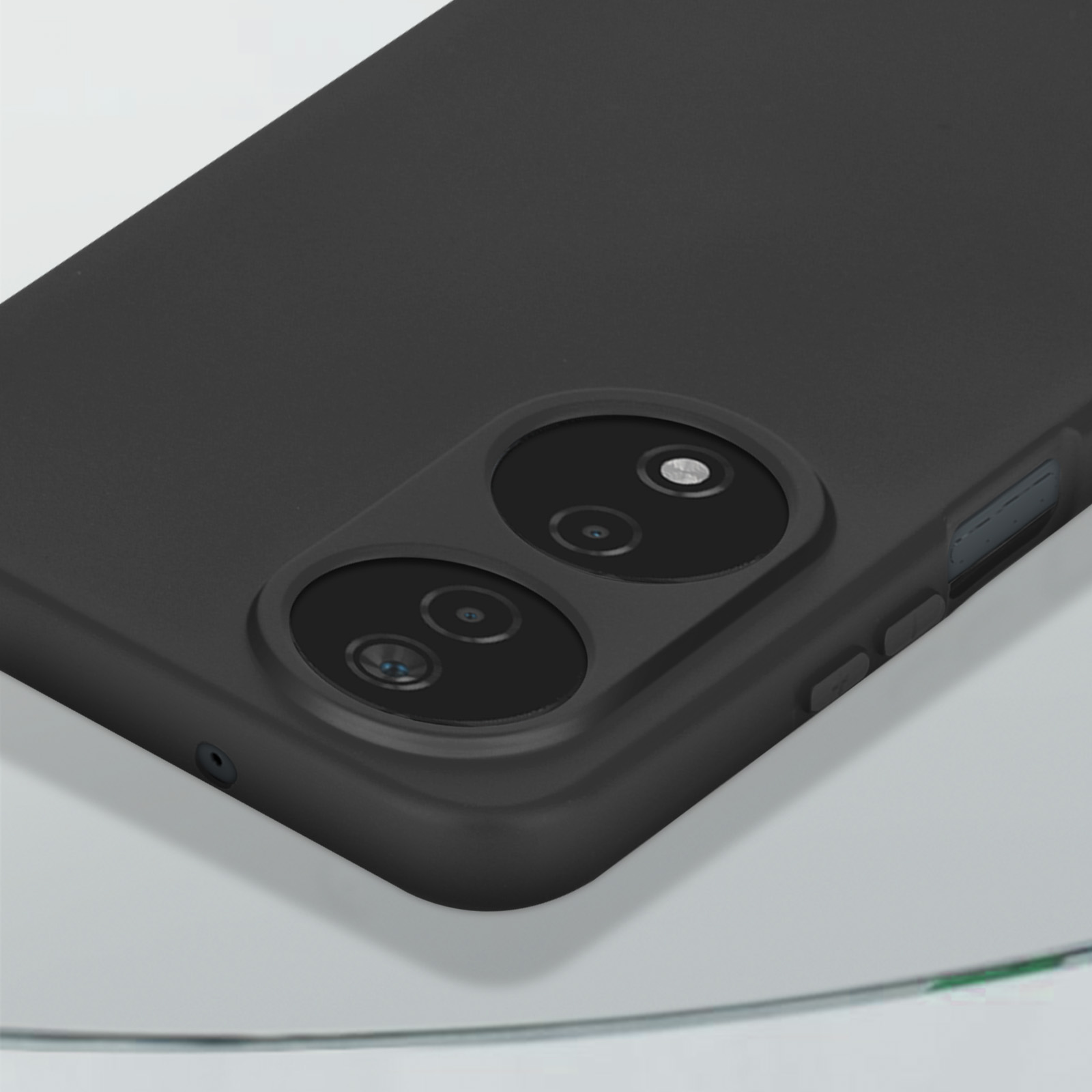 Un telefono nero con doppia fotocamera. Il telefono è su una superficie di vetro. Lo sfondo è sfocato e neutro.