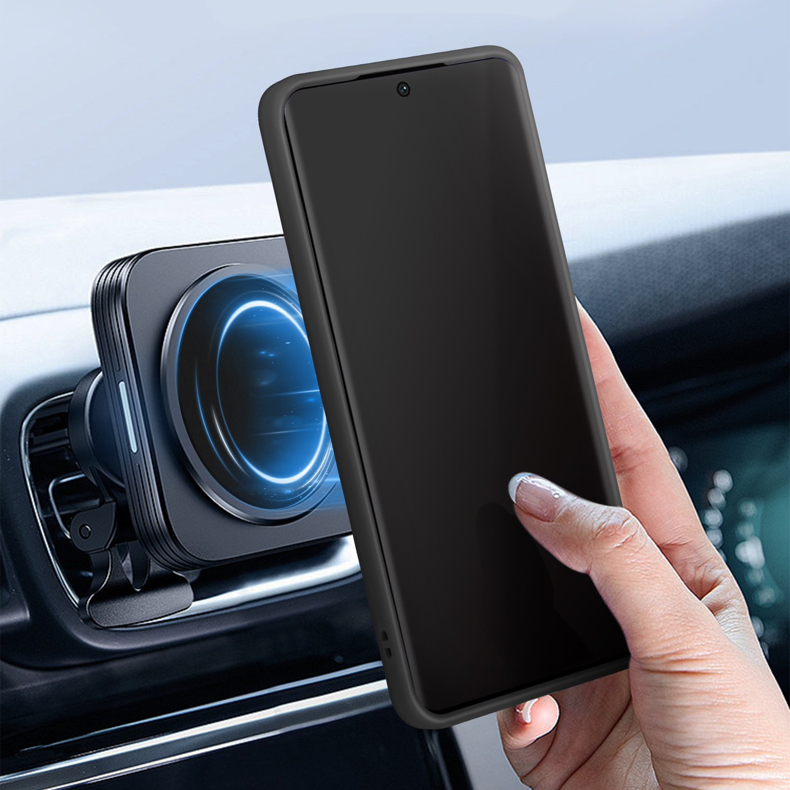 Mano che tiene un telefono nero accanto a un supporto per telefono in un'auto. Interno scuro.