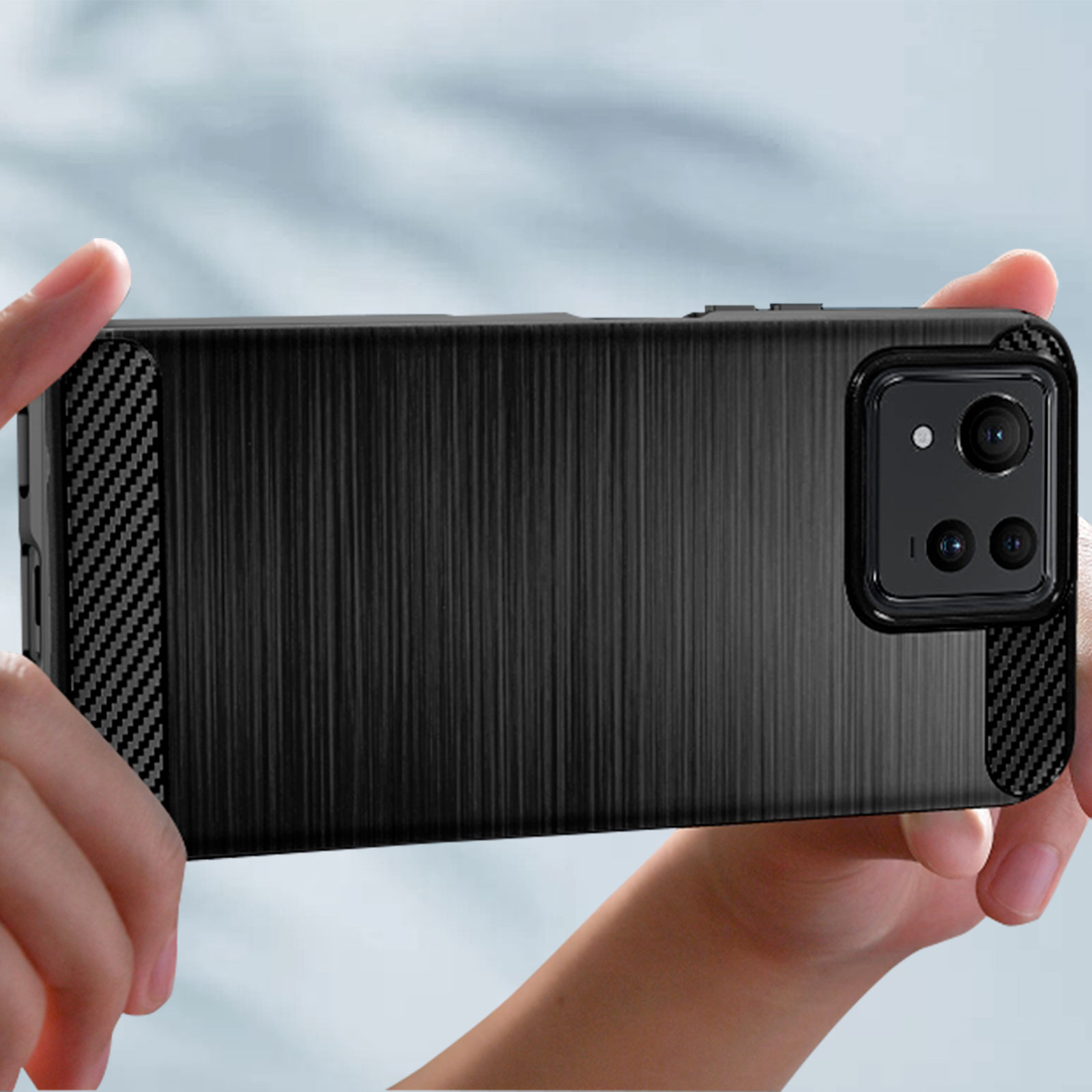 Una persona sosteniendo un teléfono en una funda negra. La funda tiene un diseño de fibra de carbono.