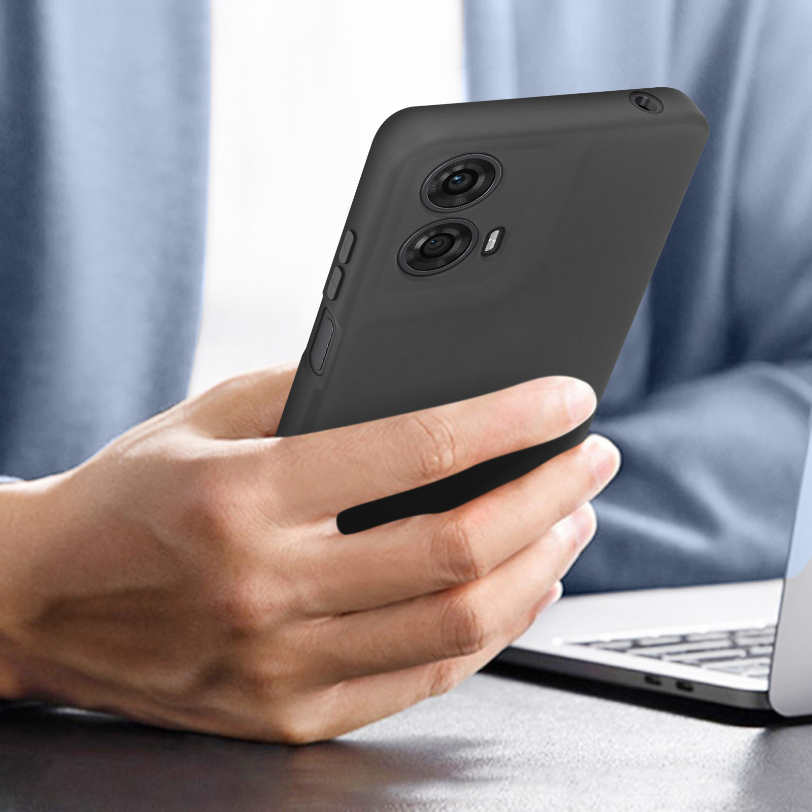 Eine Person, die ein schwarzes Telefon mit Hülle hält, die die Kamera zeigt.