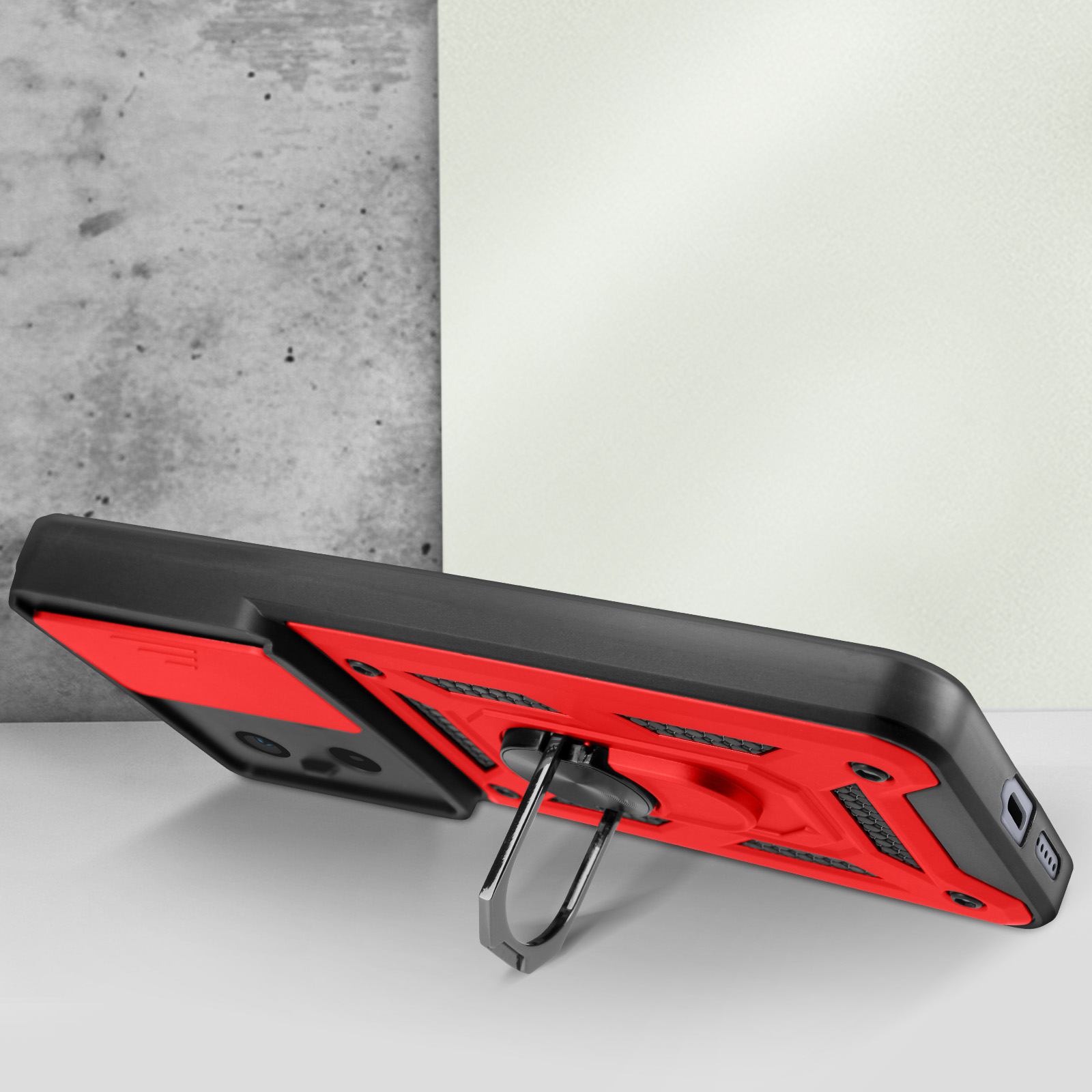 Custodia per telefono con un anello, in piedi su un tavolo bianco, rosso e nero.