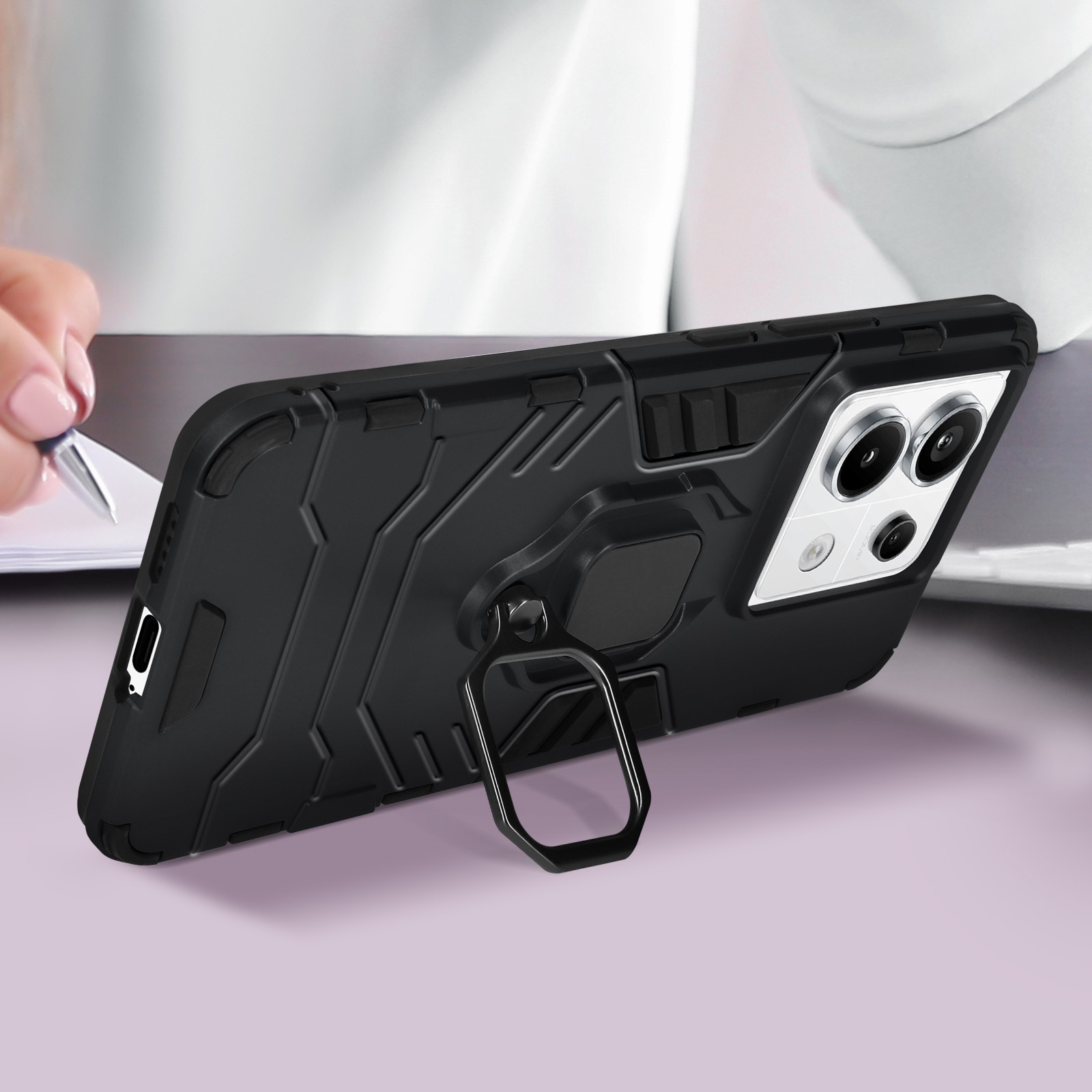 Custodia nera con supporto ad anello, telefono su un tavolo viola.