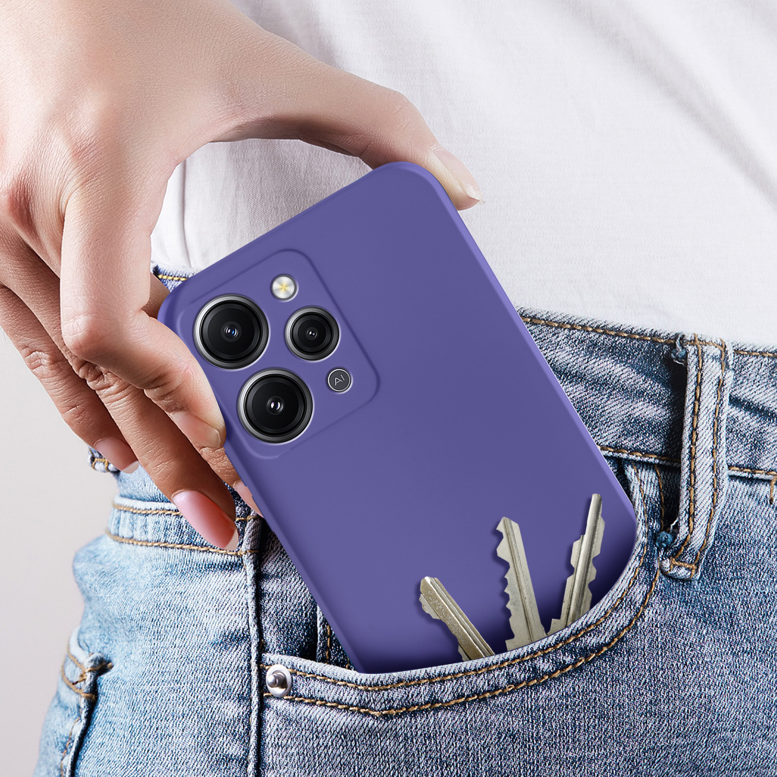 Una mano che tiene una custodia per telefono viola con chiavi in una tasca dei jeans. Il telefono ha fotocamere.