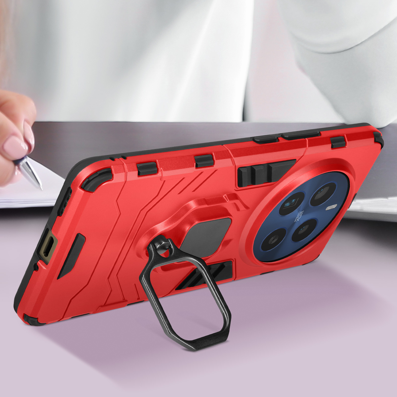 Una custodia per telefono rossa con un anello sul retro. Una mano tiene il telefono.