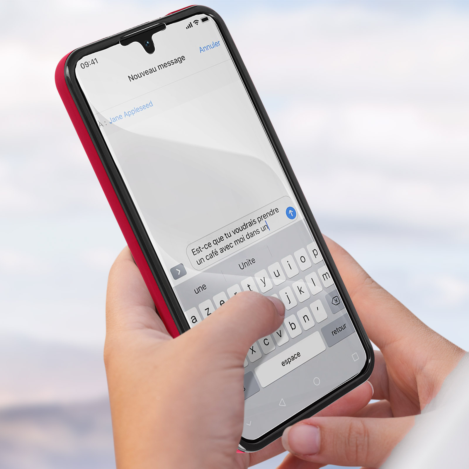 Mani che tengono un telefono, messaggi di testo. Lo schermo mostra un messaggio in francese. Custodia rossa.