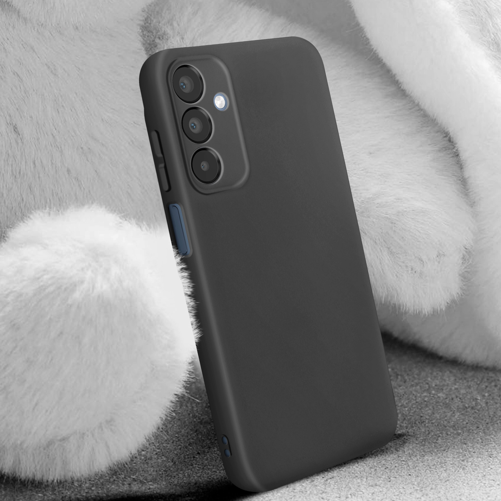 Custodia nera per telefono, con fotocamere, appoggiata su pelliccia bianca. Sfondo sfocato.