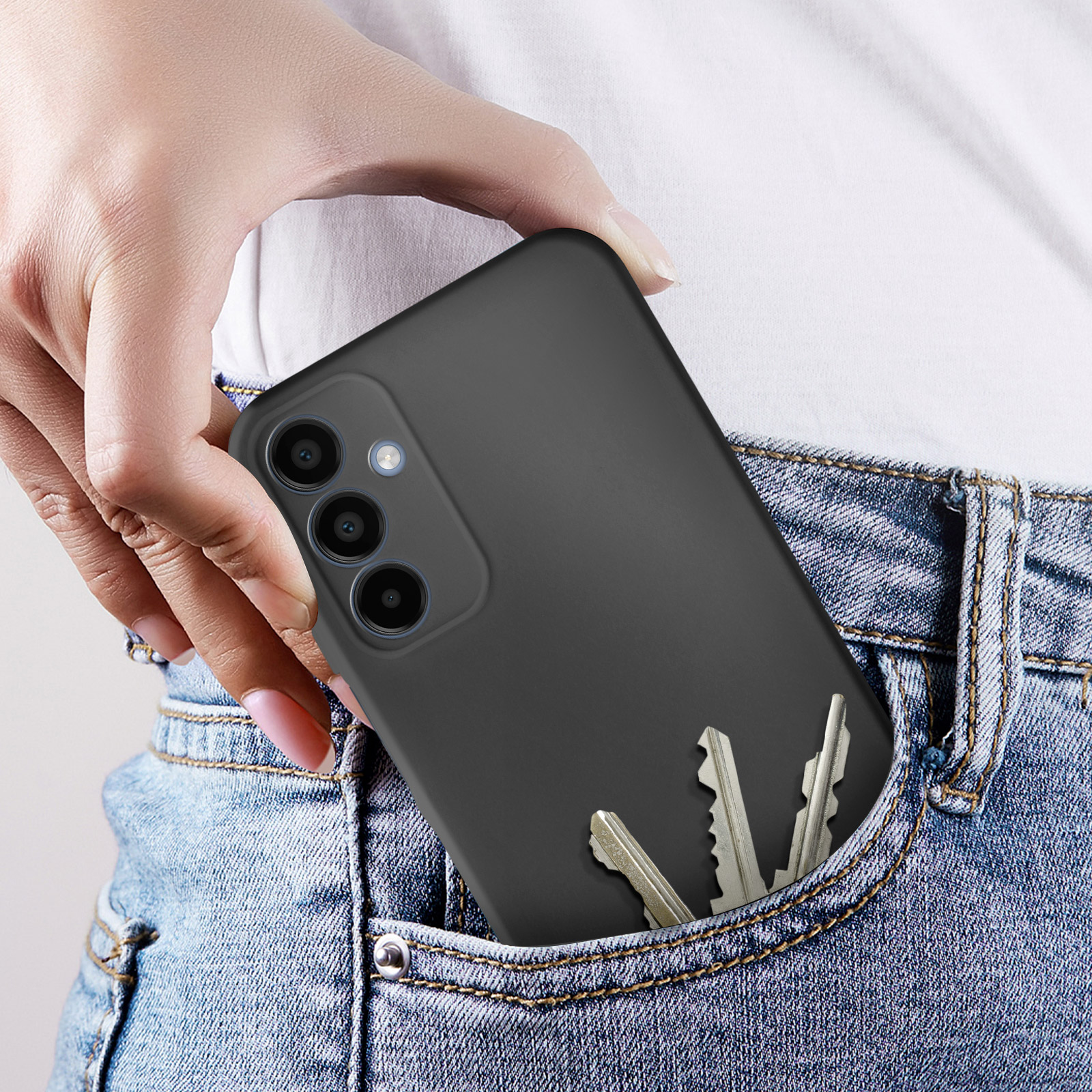 Mano in tasca con telefono in custodia nera. Le chiavi sono anche in tasca.