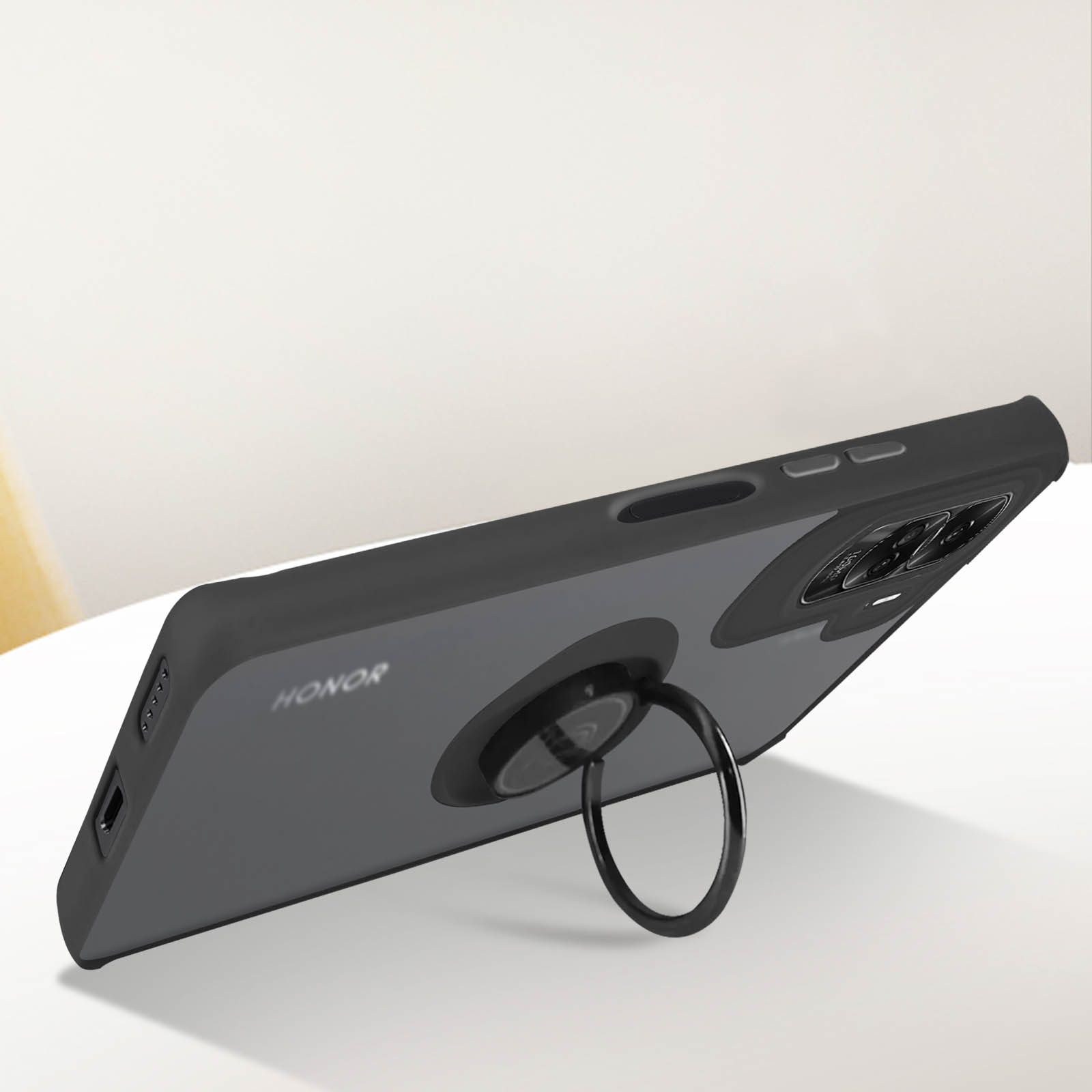 Telefoon in een zwarte hoes met een ringhouder. HONOR-merk is zichtbaar. Achtergrond is een wit oppervlak.