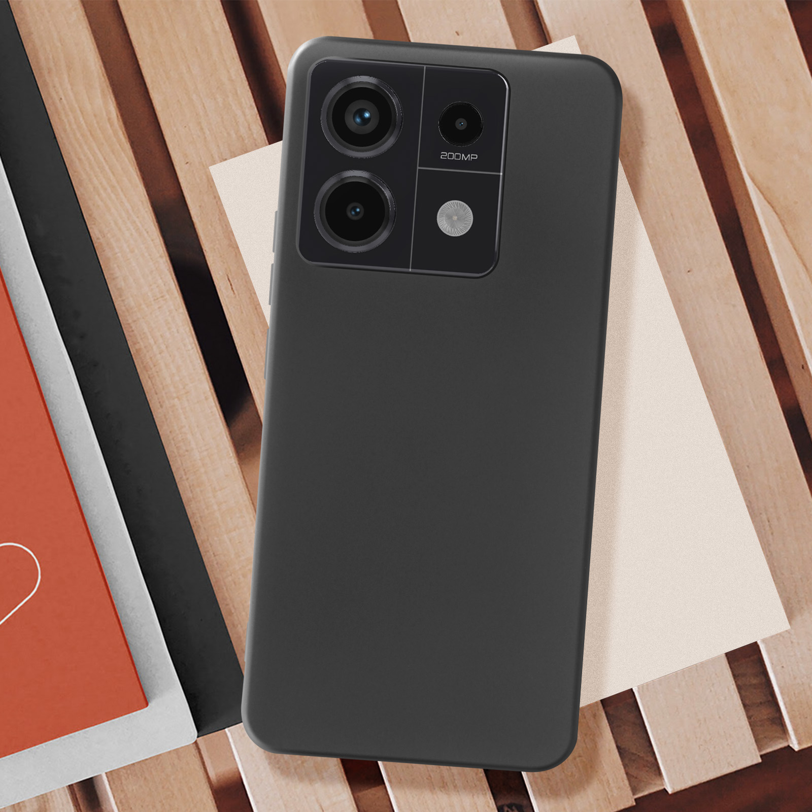 Custodia per telefono nera. La custodia è su una superficie in legno e ha una fotocamera e un'etichetta da 200MP.