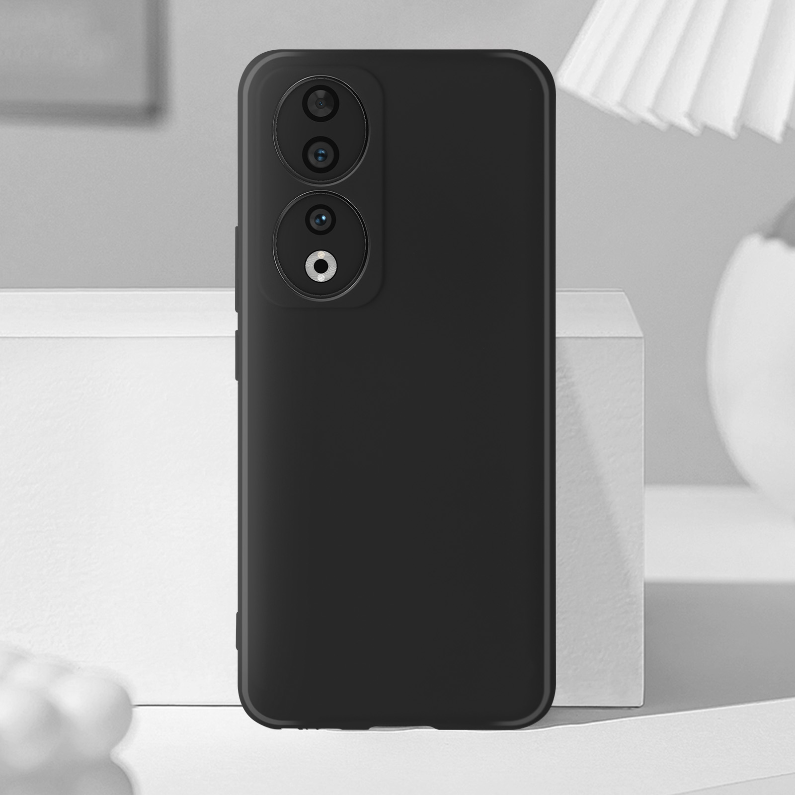 Een zwarte telefoonhoes op een wit oppervlak. De hoes heeft twee cameralenzen.