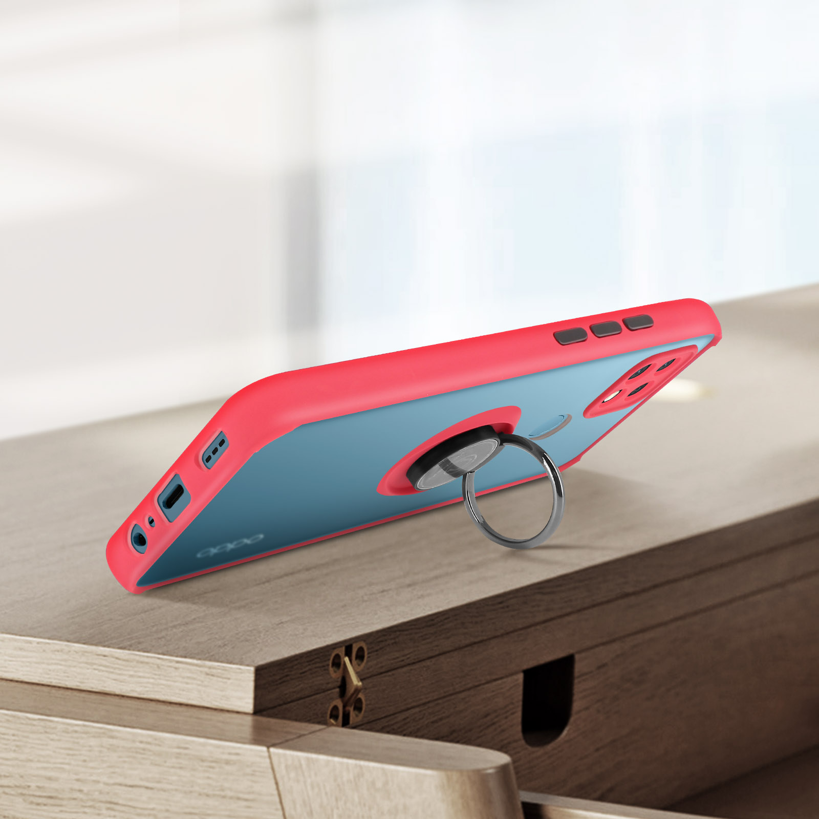 Custodia per telefono con supporto ad anello su superficie in legno, rosa e blu.