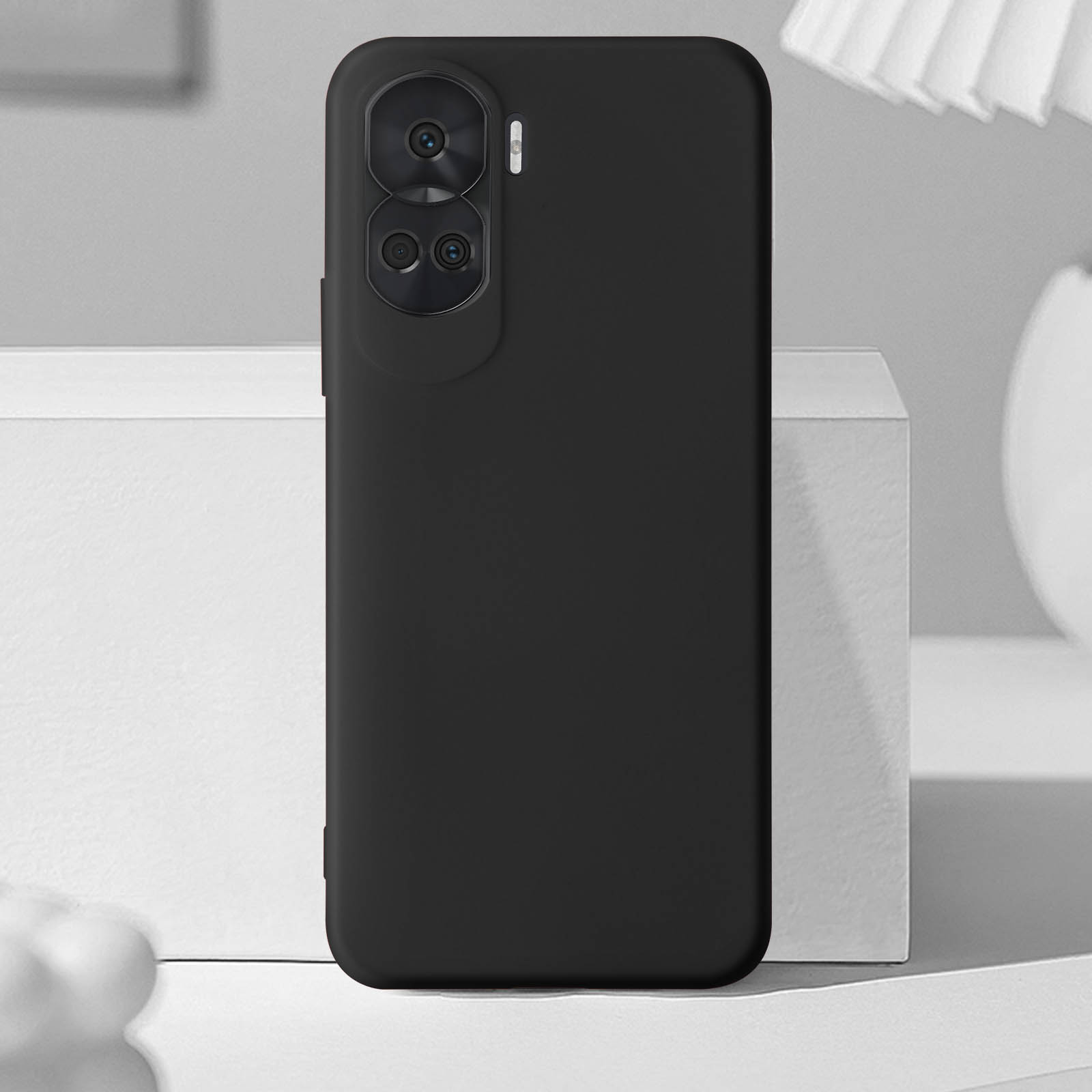 Una custodia nera per telefono con un rigonfiamento della fotocamera e uno sfondo nero. Il telefono è rivolto verso l'alto.