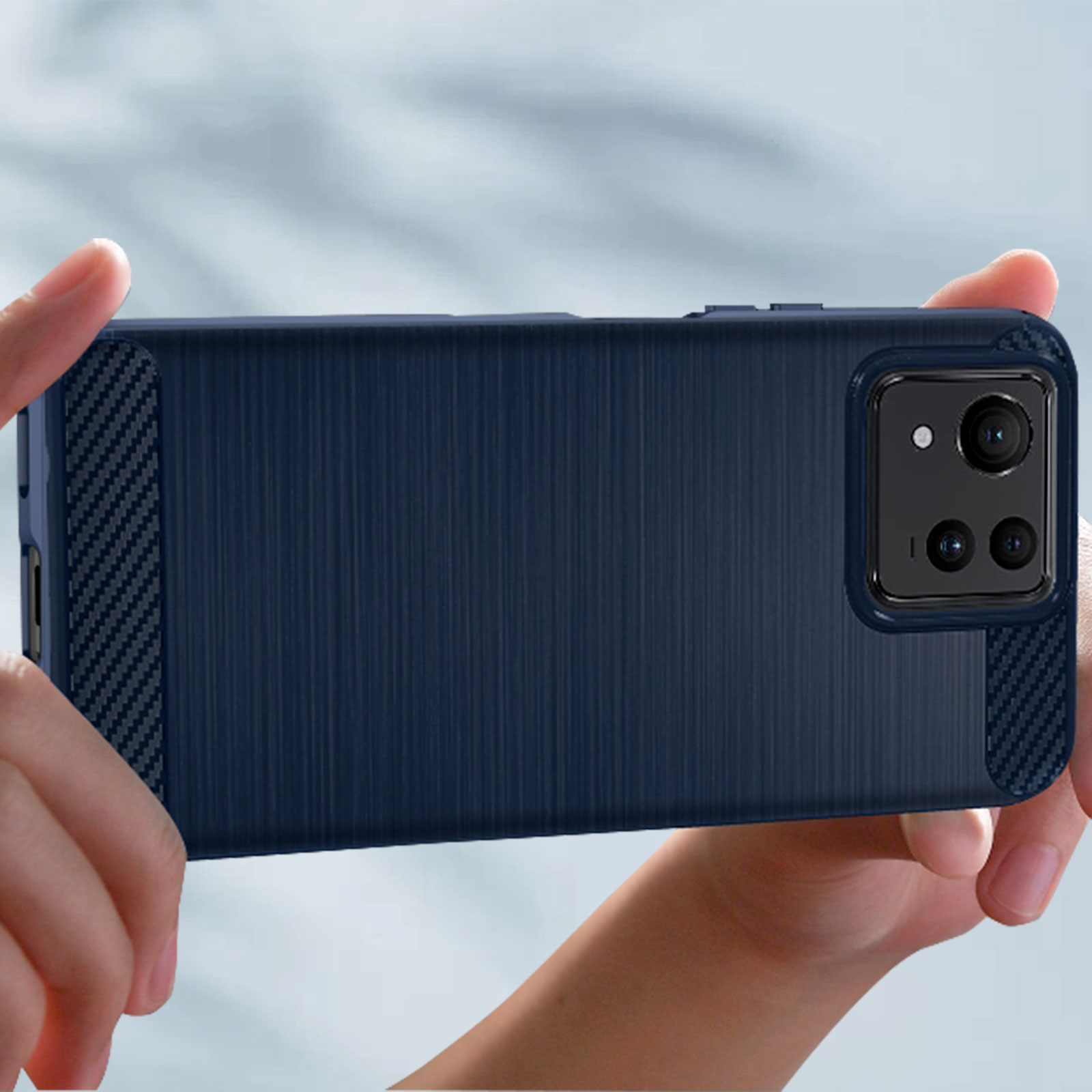 Funda azul para teléfono sujeta por manos, con textura de fibra de carbono.