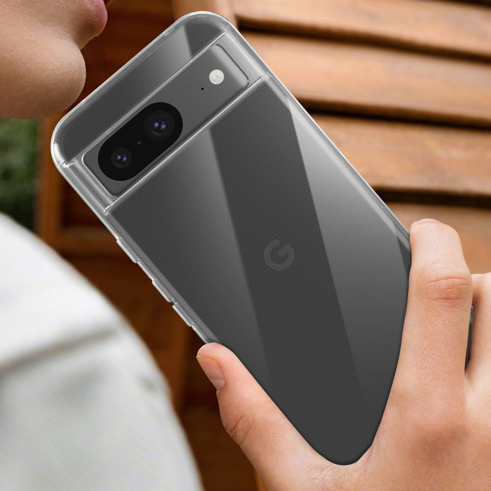 Una mano che tiene una custodia trasparente per telefono, mostrando la fotocamera e il retro.