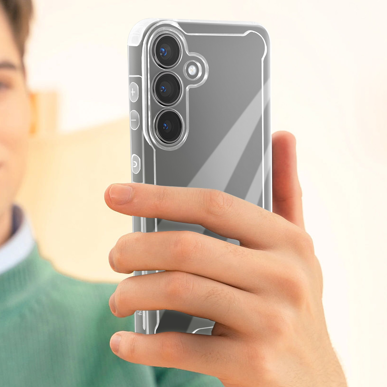 Un uomo tiene in mano un telefono con una custodia trasparente. Lo sfondo è sfocato.