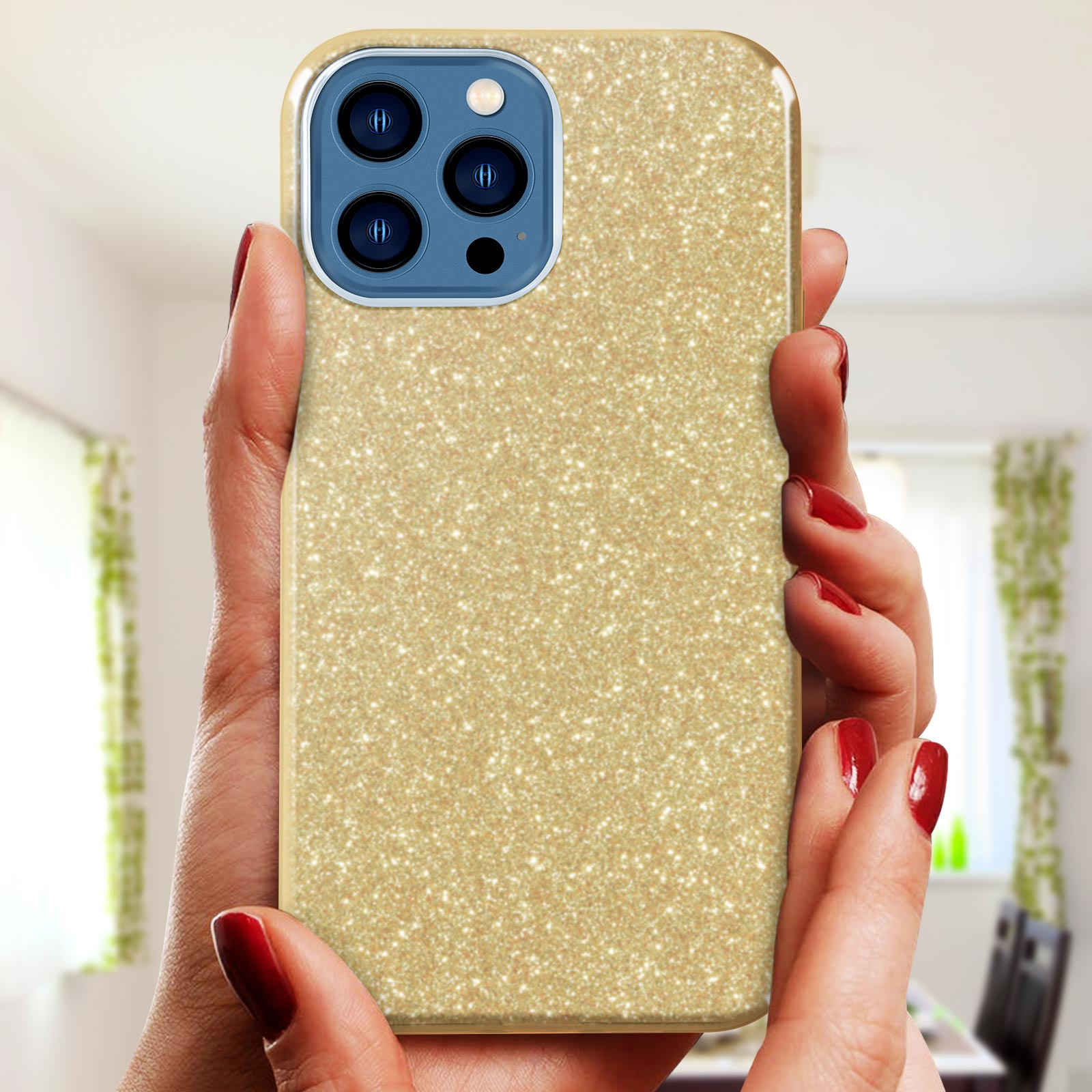 Mani che tengono un telefono con una custodia dorata glitterata. Lo sfondo è sfocato.