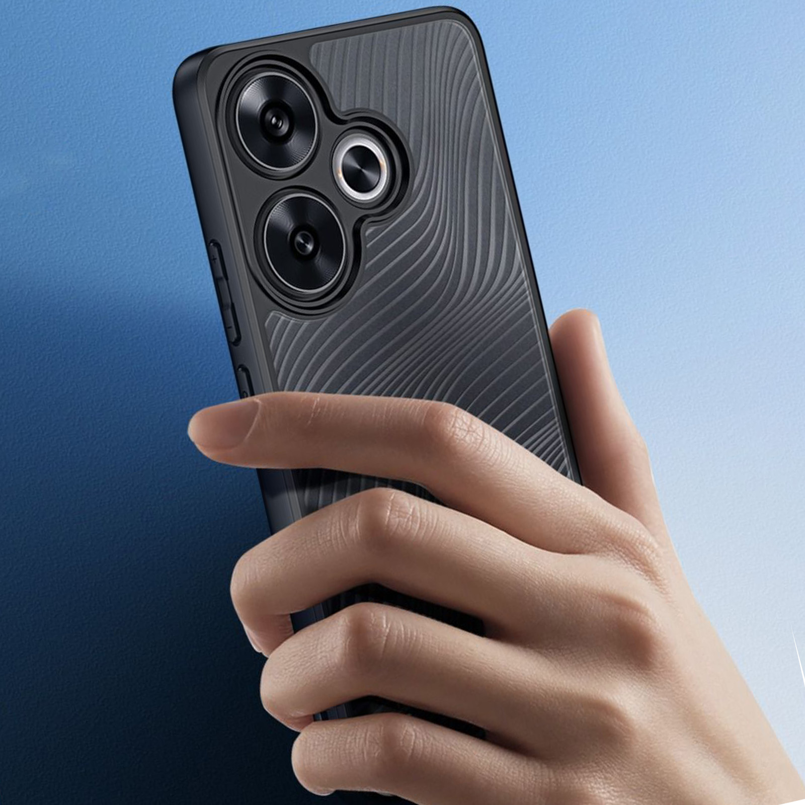 Una mano tiene un telefono nero, mostrando l'area della fotocamera del telefono.