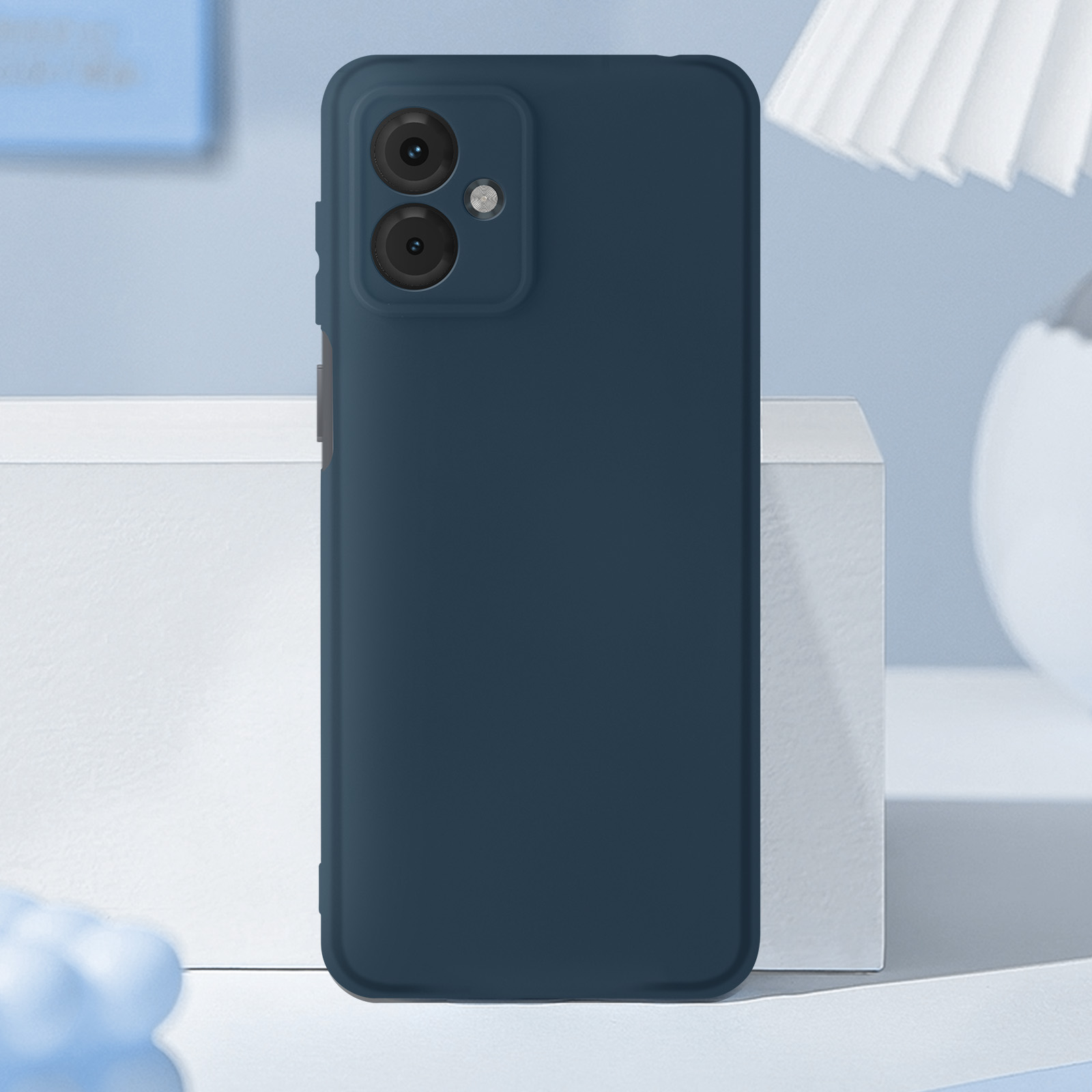 Telefono blu scuro su una superficie bianca. Ha due fotocamere.