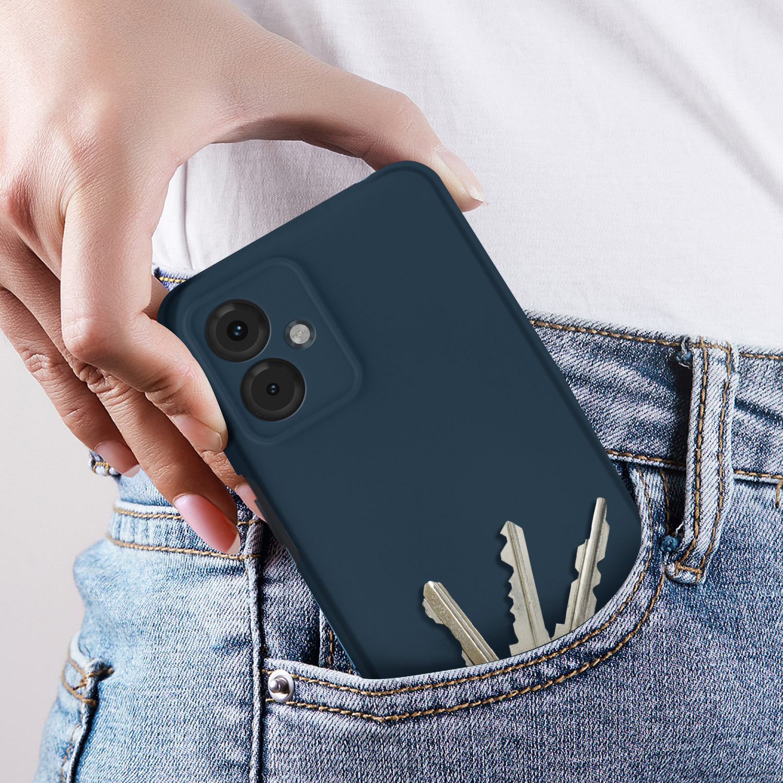 Una mano che tiene un telefono in una custodia blu con chiavi in tasca.