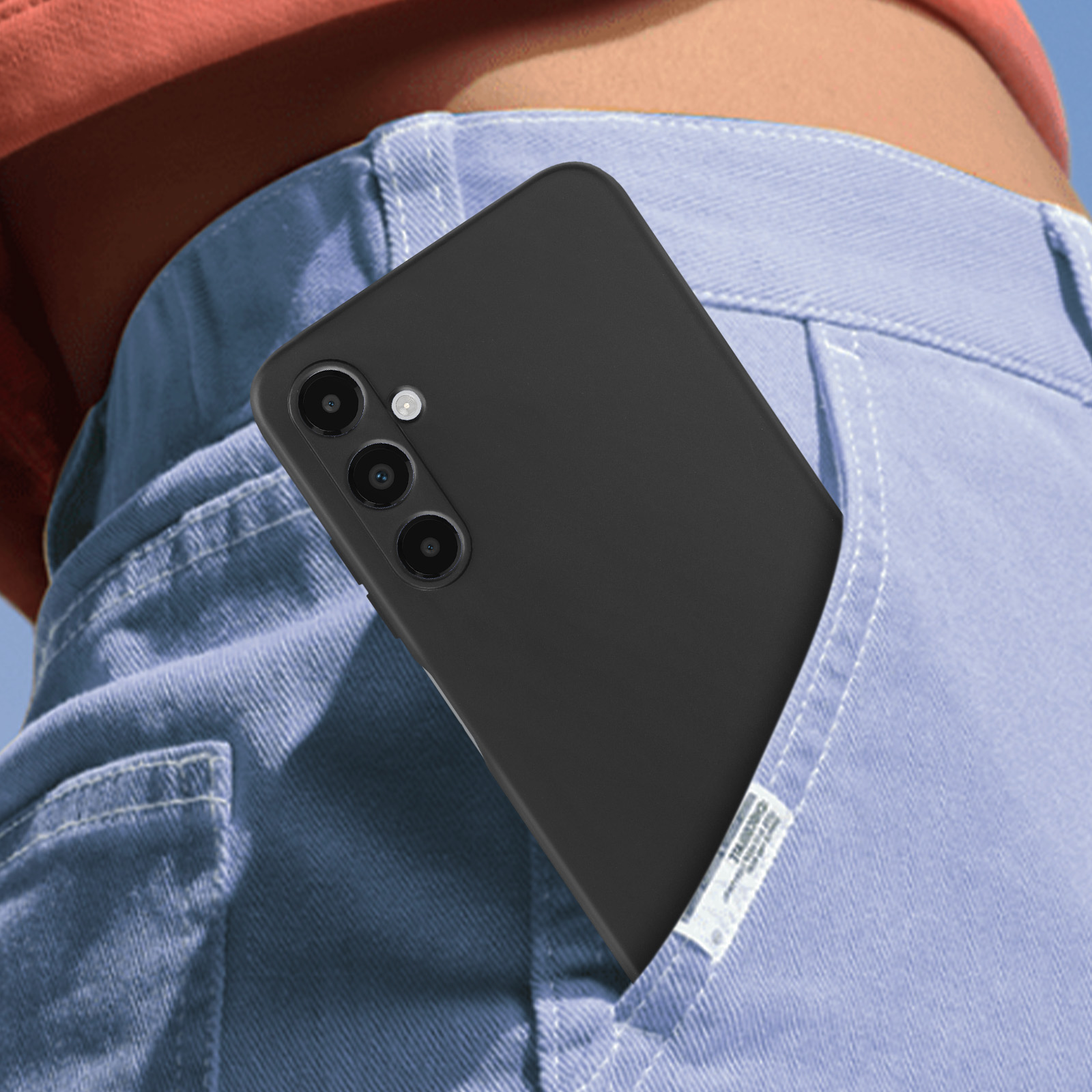 Telefono nero in una tasca di jeans blu.