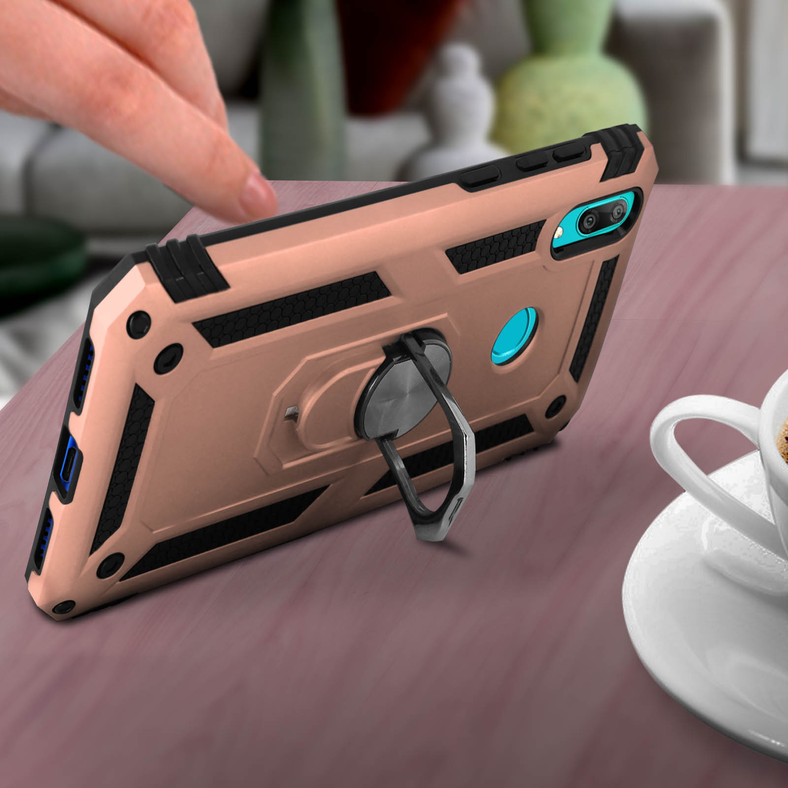 Custodia con anello. La mano tocca il telefono. Sfondo tavolo.