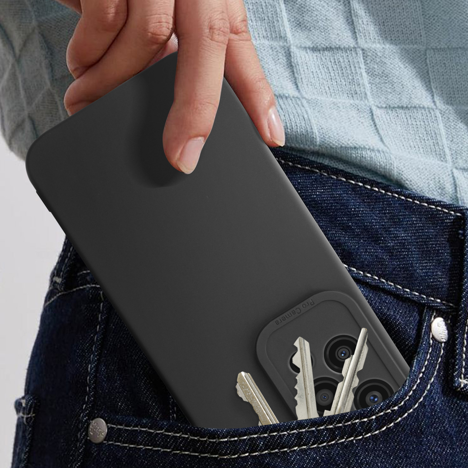 Mano che mette un telefono nero con custodia in una tasca di jeans con chiavi.
