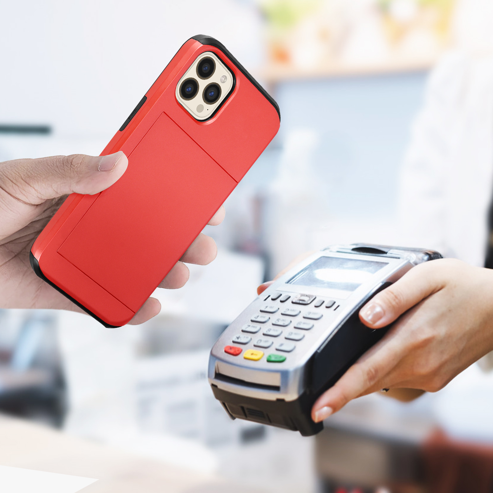 Una mano che tiene una custodia rossa vicino a un lettore di carte. Sfondo sfocato di un negozio.