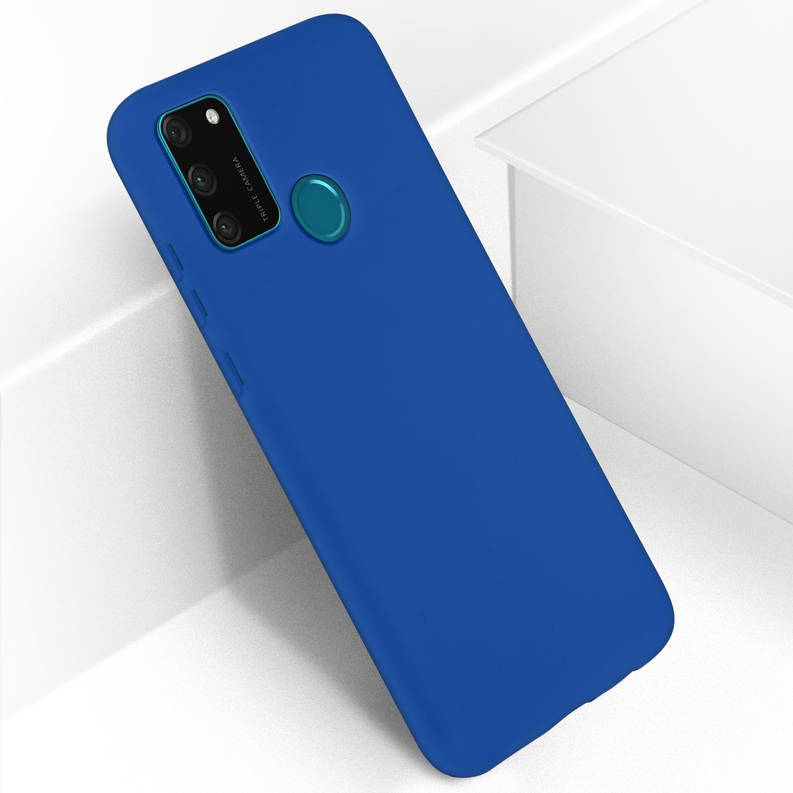 Custodia blu con ritaglio per fotocamera e supporto ad anello. Davanti a una superficie bianca.