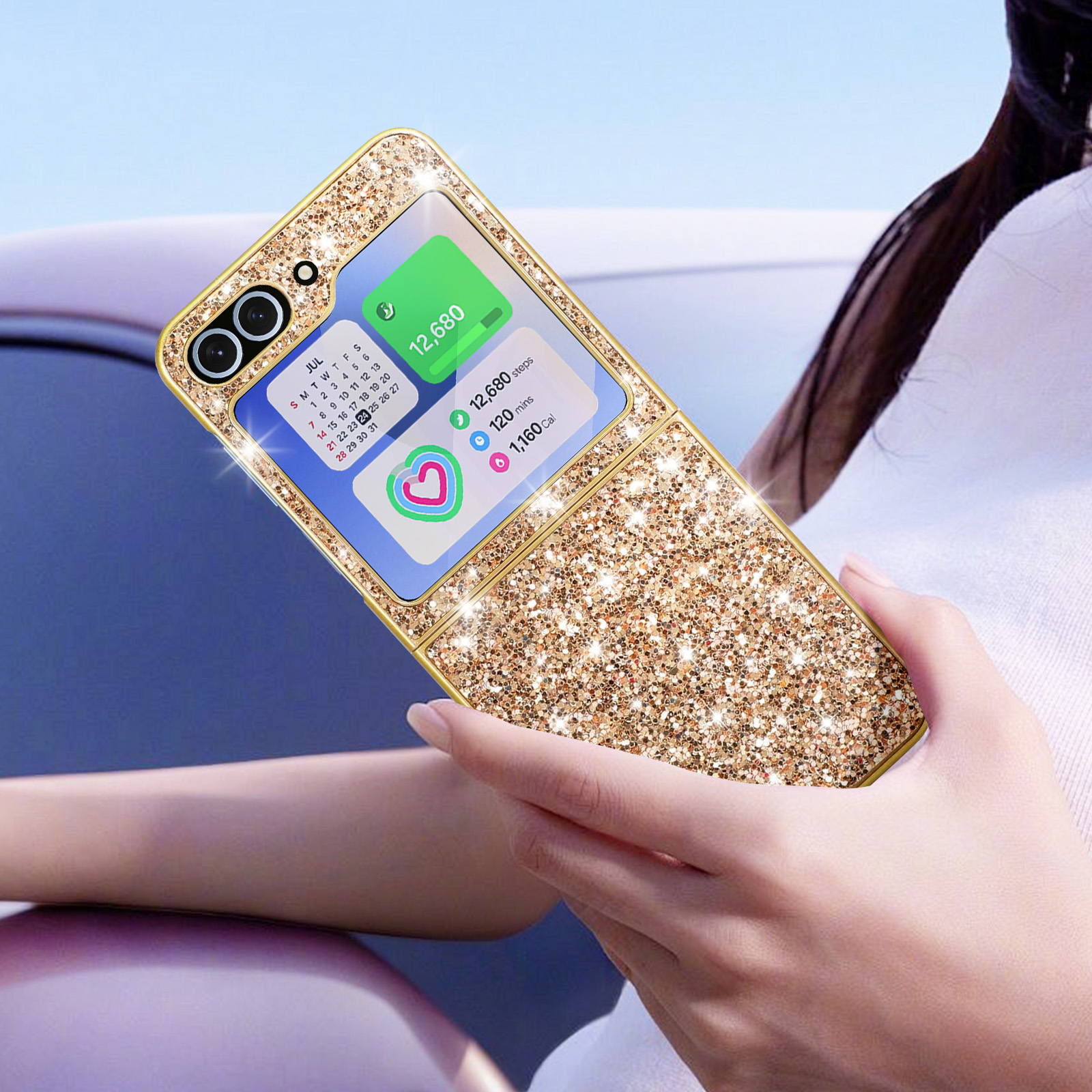 Una donna tiene un telefono glitterato d'oro. Mostra calendario e app salute.