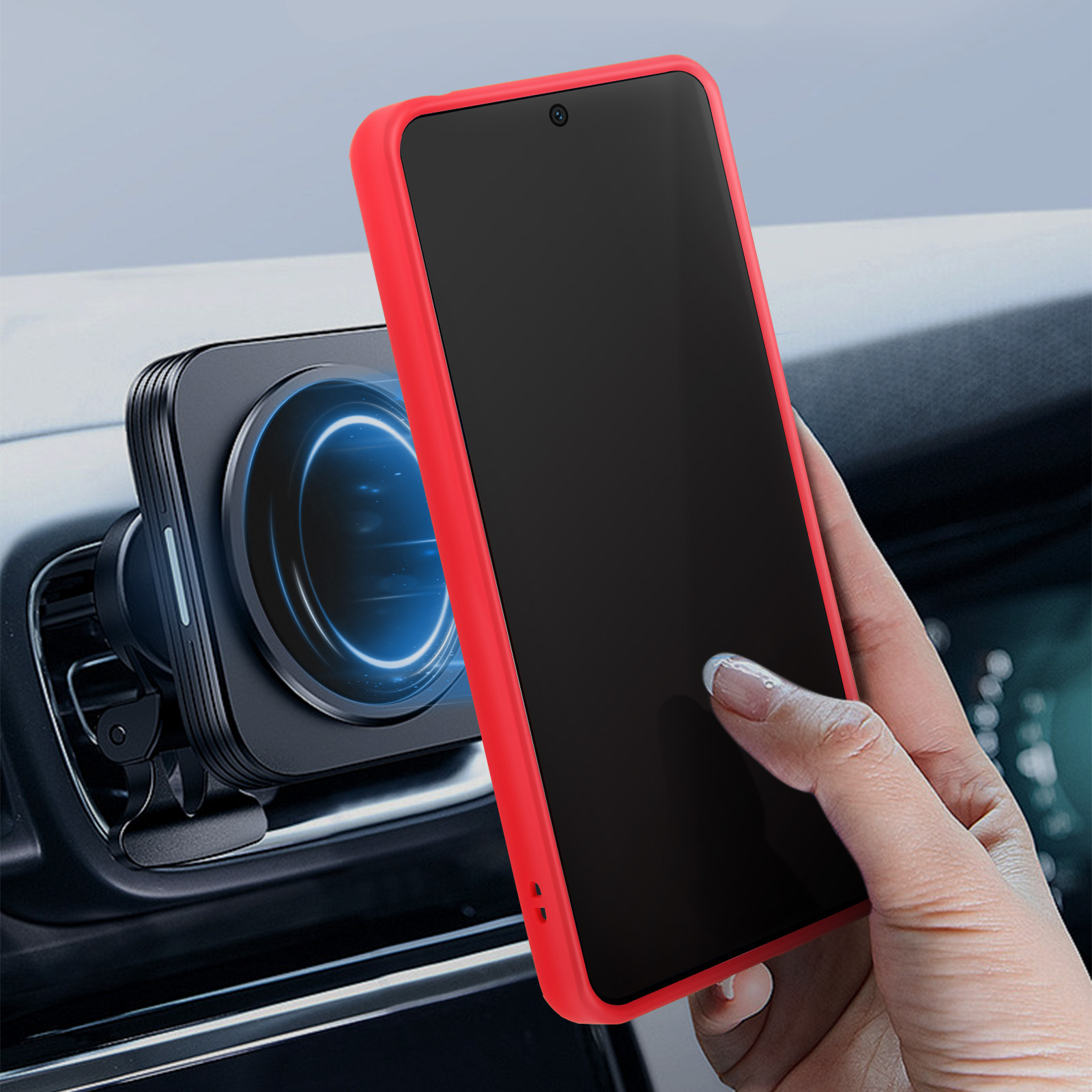 Una mano che tiene un telefono con custodia rossa, montato nella presa d'aria di un'auto.