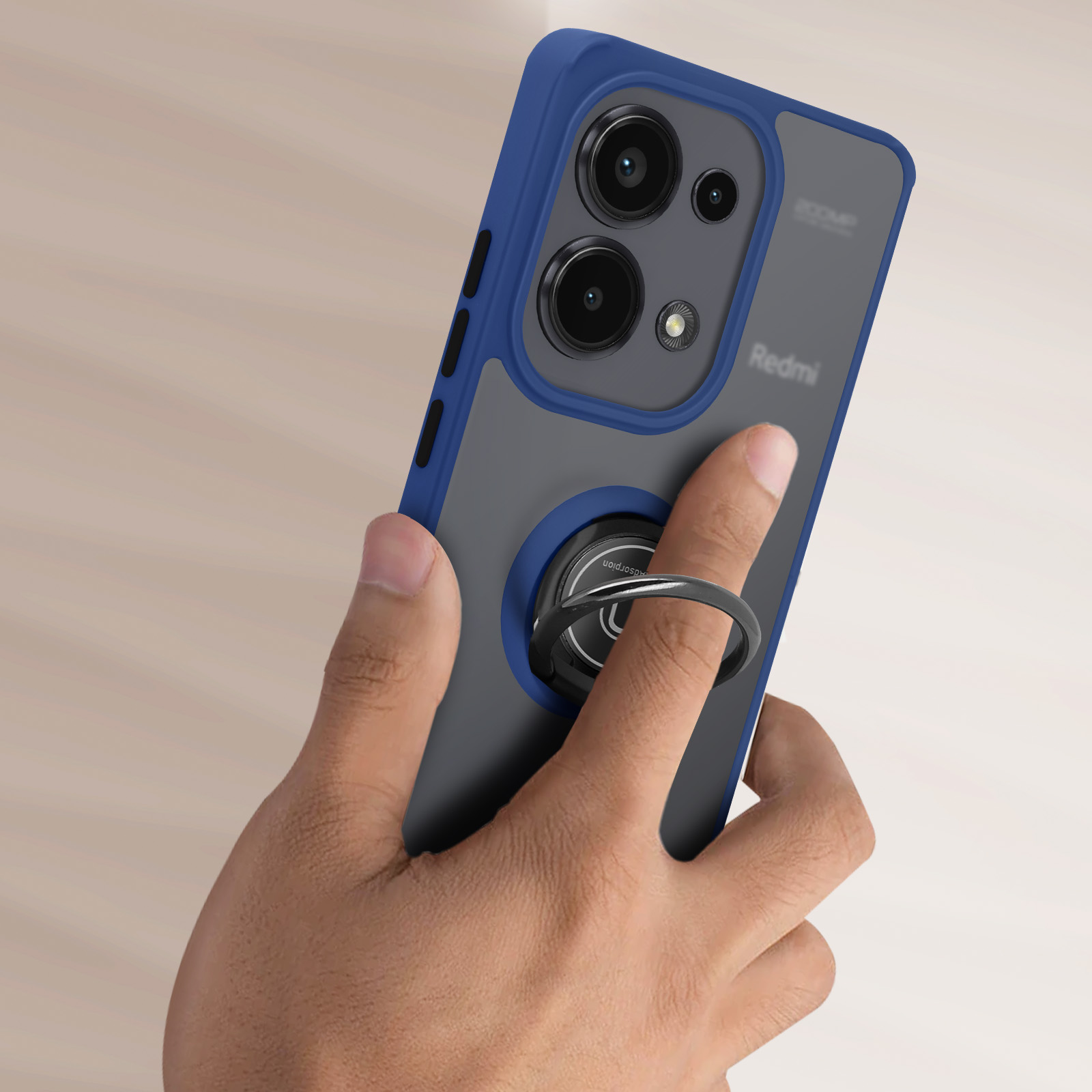 Mano che tiene una custodia per telefono. La custodia è blu e grigia. Il telefono ha lenti della fotocamera e un anello.