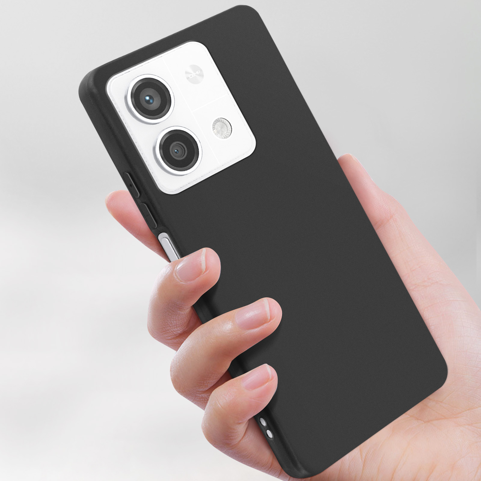 Telefono in mano. Telefono nero e custodia nera. Due fotocamere visibili.