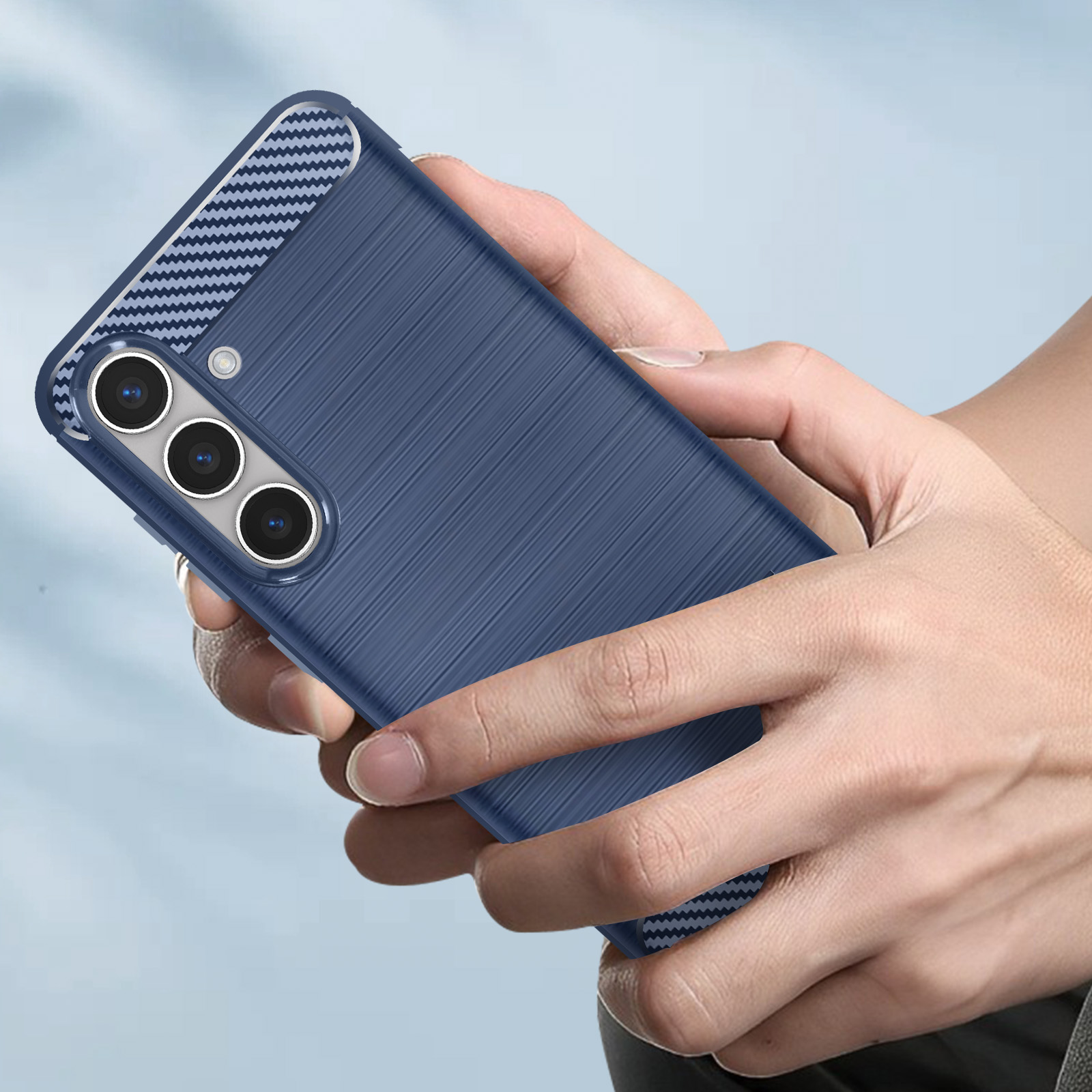 La mano di una persona tiene una custodia blu con un design strutturato. La custodia ha tre obiettivi.