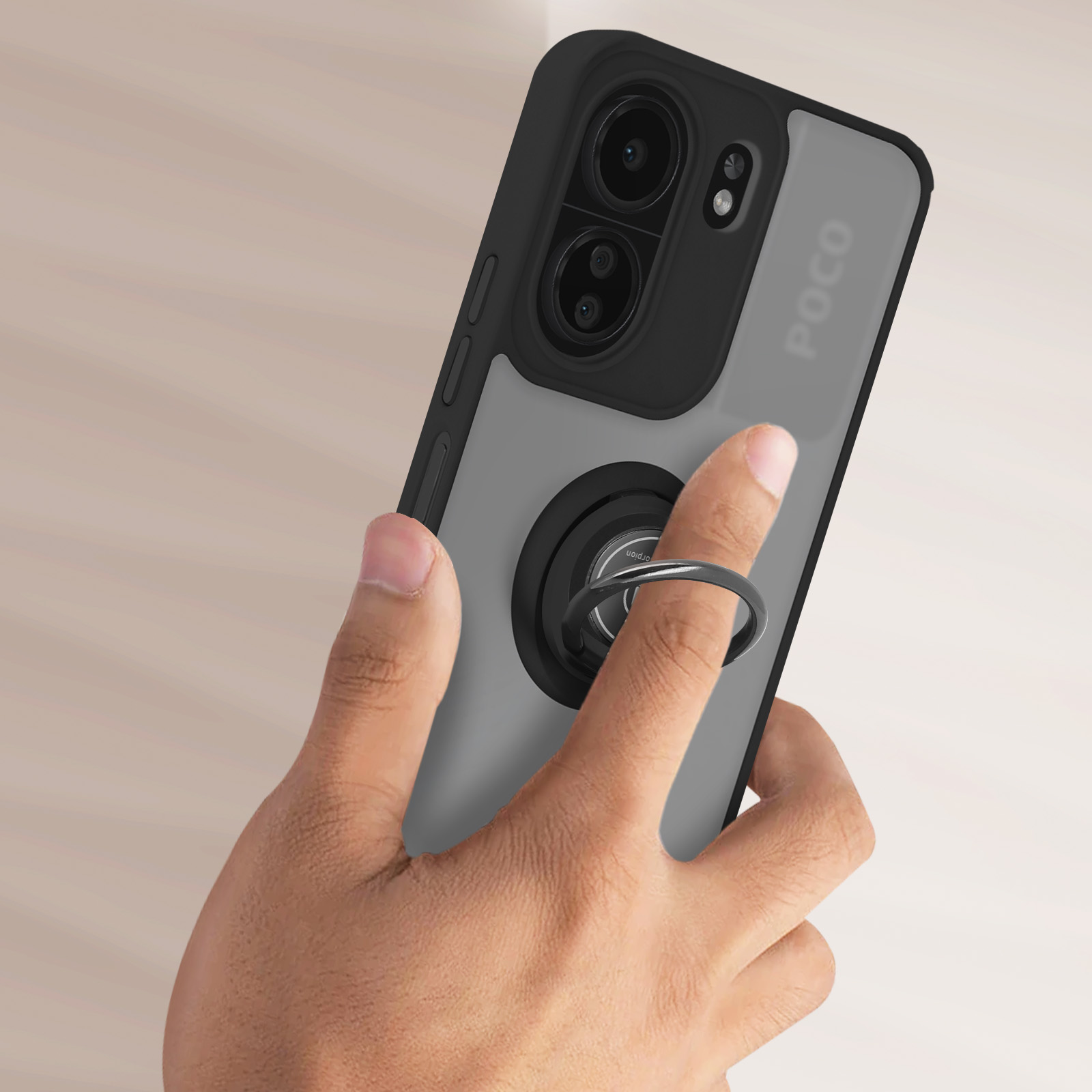 Mano che tiene un telefono con un portanello. Il telefono è nero e grigio.